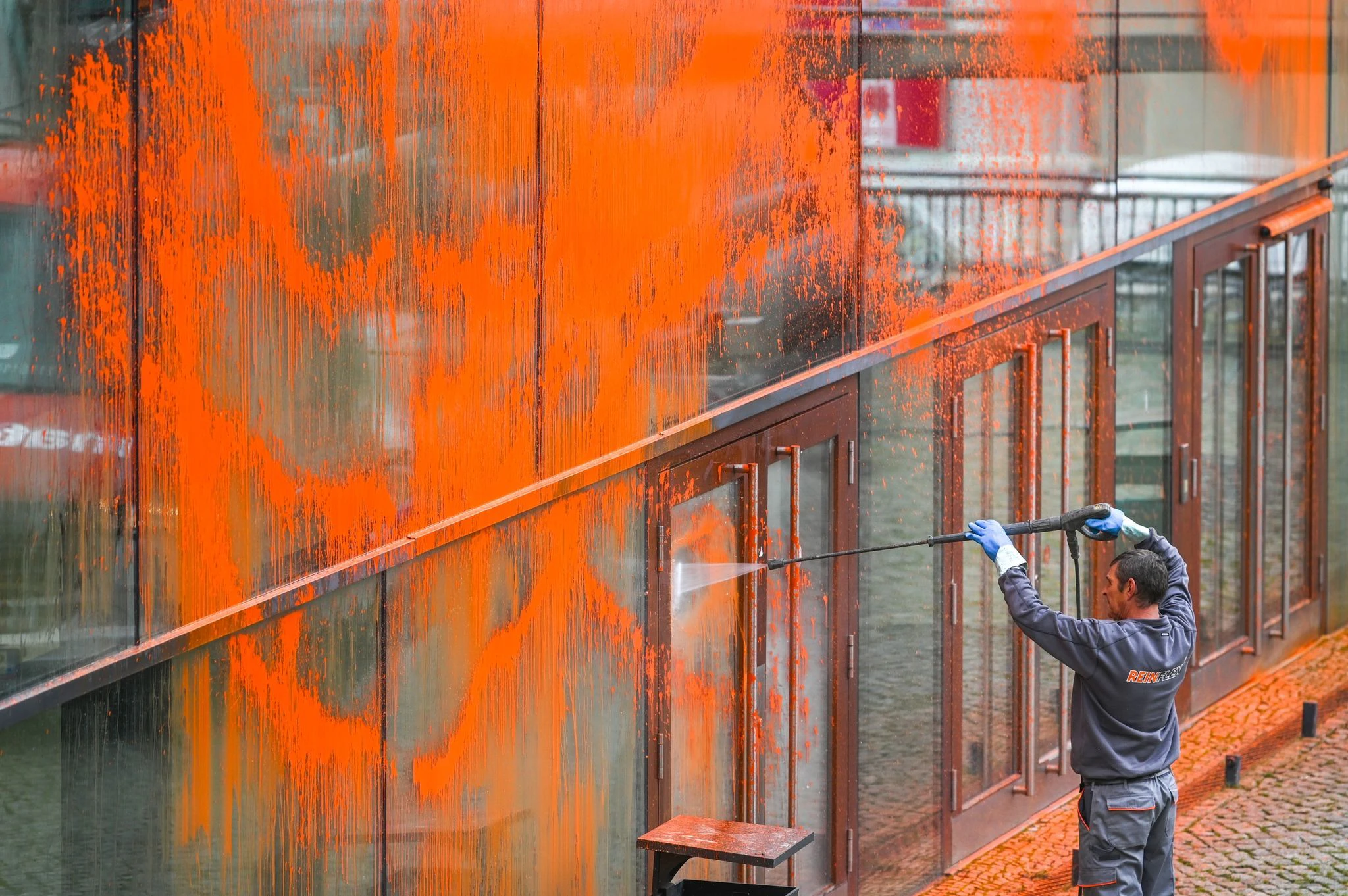 Klimaaktivisten der Letzten Generation haben in Halle ein Gebäude der Martin-Luther-Universität mit orangener Farbe beschmiert. Die Glasfassade muss nun mit einem Hochdruckreiniger gereinigt werden.  