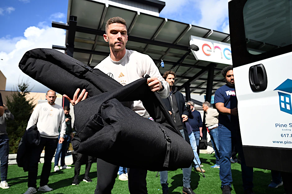Union Berlins Nationalspieler Robin Gosens packt bei einem Community-Event Pakete für Obdachlose.