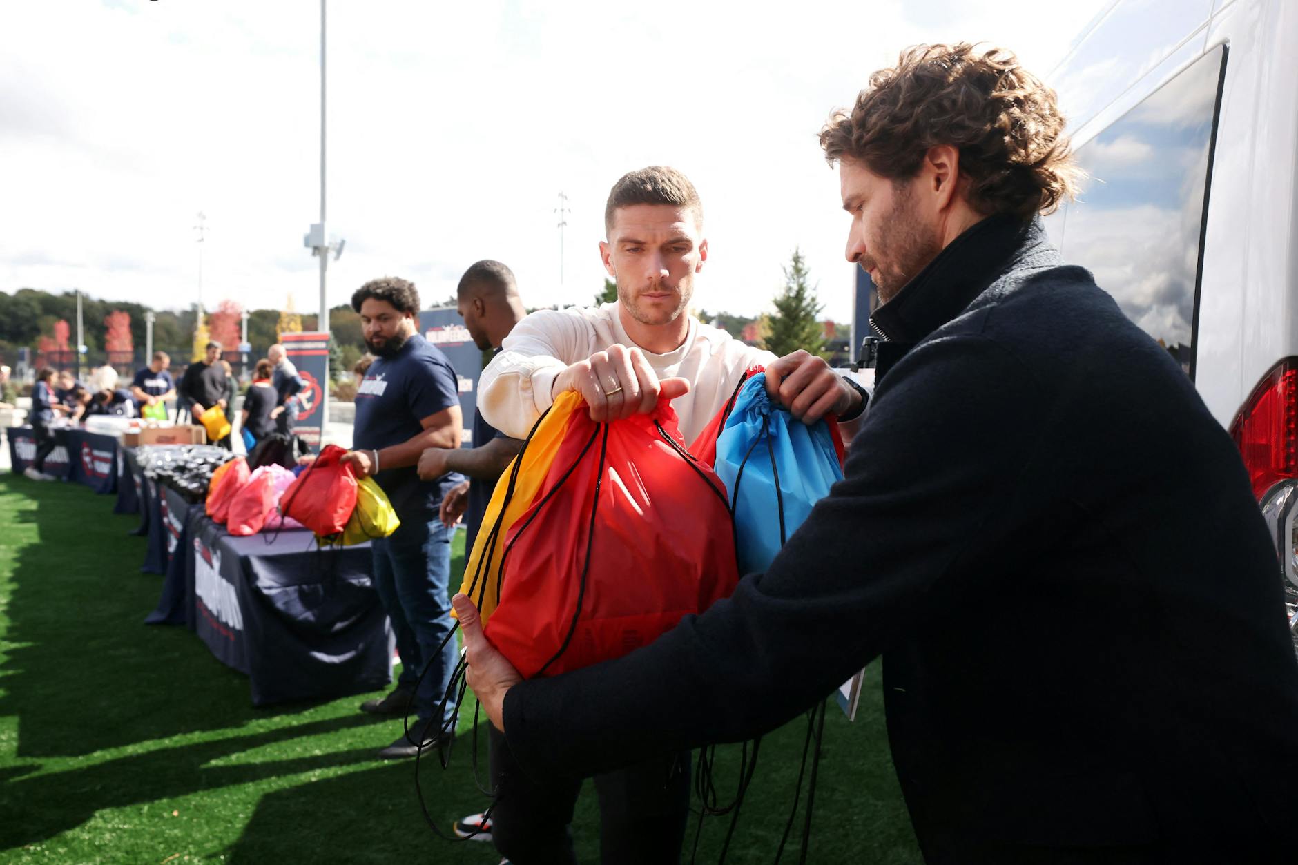Zusammen mit Stars des NFL-Teams New England Patriots packten Robin Gosens (l.) und Arne Friedrich mit an.