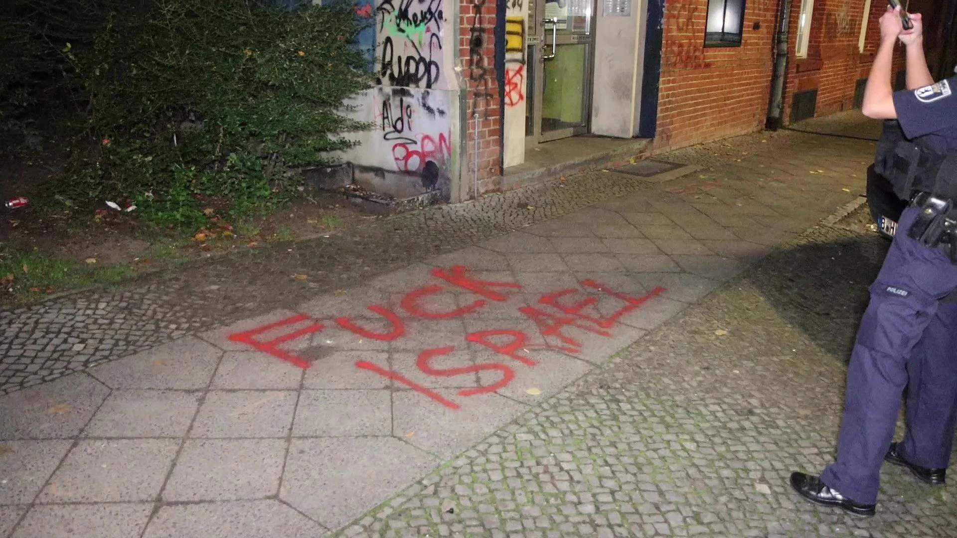 Hass-Schmierereien auf dem Gehweg, an den Hauseingang wurde ein durchgestrichener Davidstern und eine Palästinenser-Fahne gesprüht.