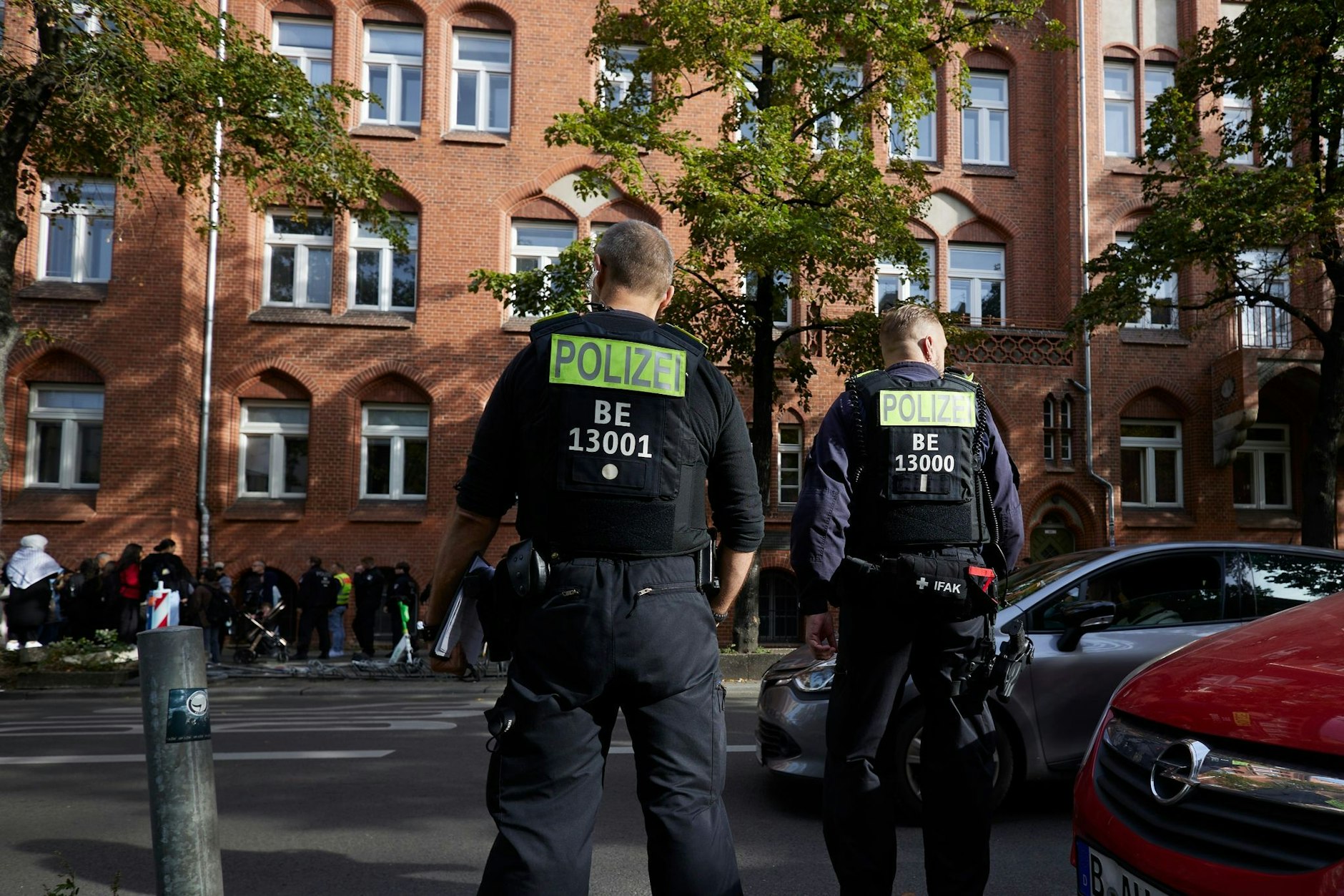Polizisten stehen vor dem Ernst-Abbe-Gymnasium in der Sonnenallee im Berliner Stadtteil Neukölln. 