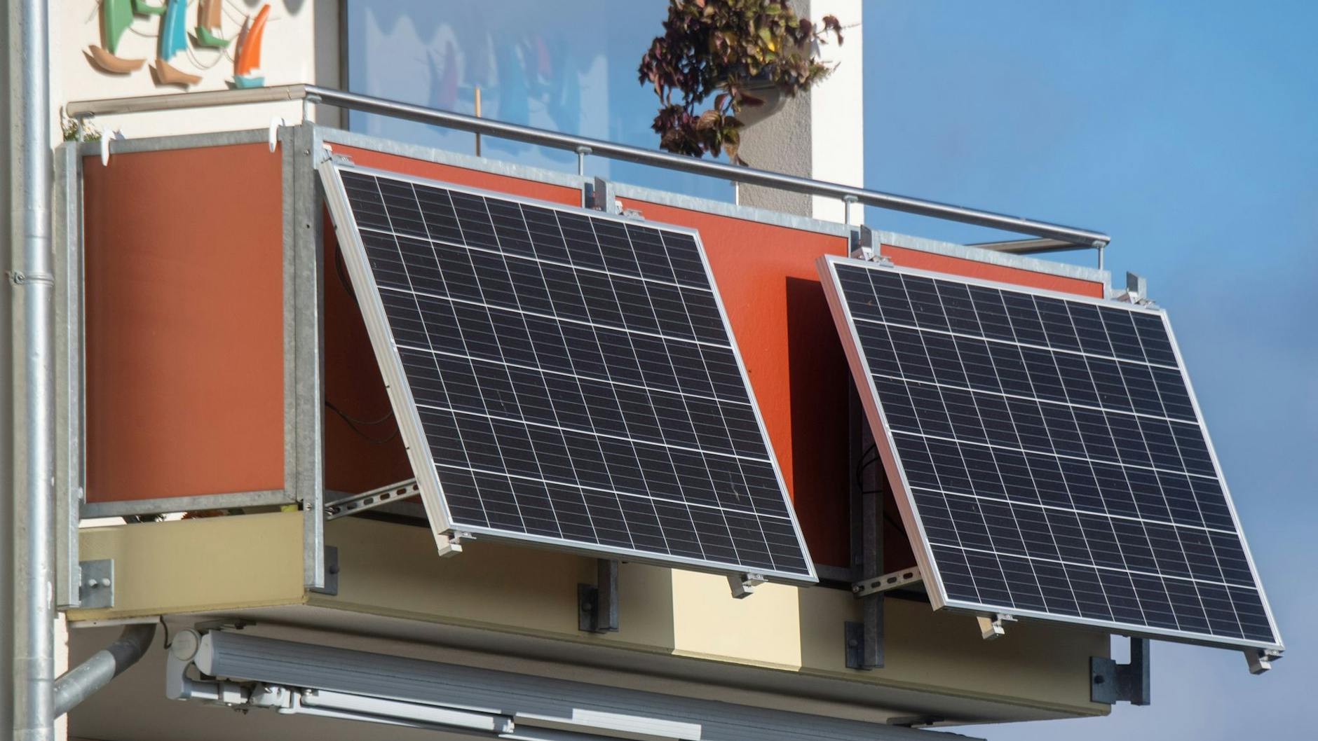 Solarmodule für ein sogenanntes Balkonkraftwerk hängen an einem Balkon.