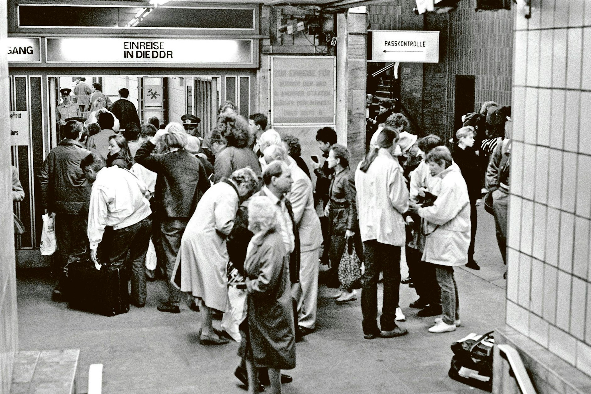 Menschen warten vor dem Grenzübergang zur DDR auf dem Bahnhof Friedrichstraße.