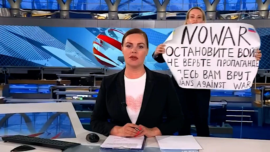ARCHIV - Marina Owsjannikowa (r) mit einem Protestplakat mit der Aufschrift Stoppt den Krieg