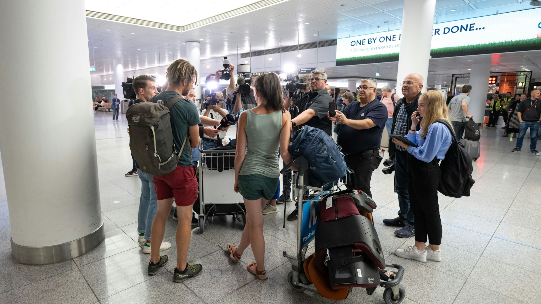 Die Touristen Franziska (M) und Alex sprechen mit Medien, nachdem sie mit einem von der Bundesregierung organisierten Sonderflug der Lufthansa aus Tel Aviv, Israel, am Flughafen München ankamen.&nbsp;