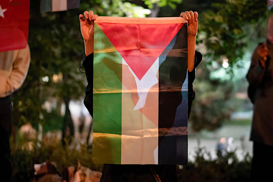 Eine Frau hält eine Palästina-Flagge hoch.