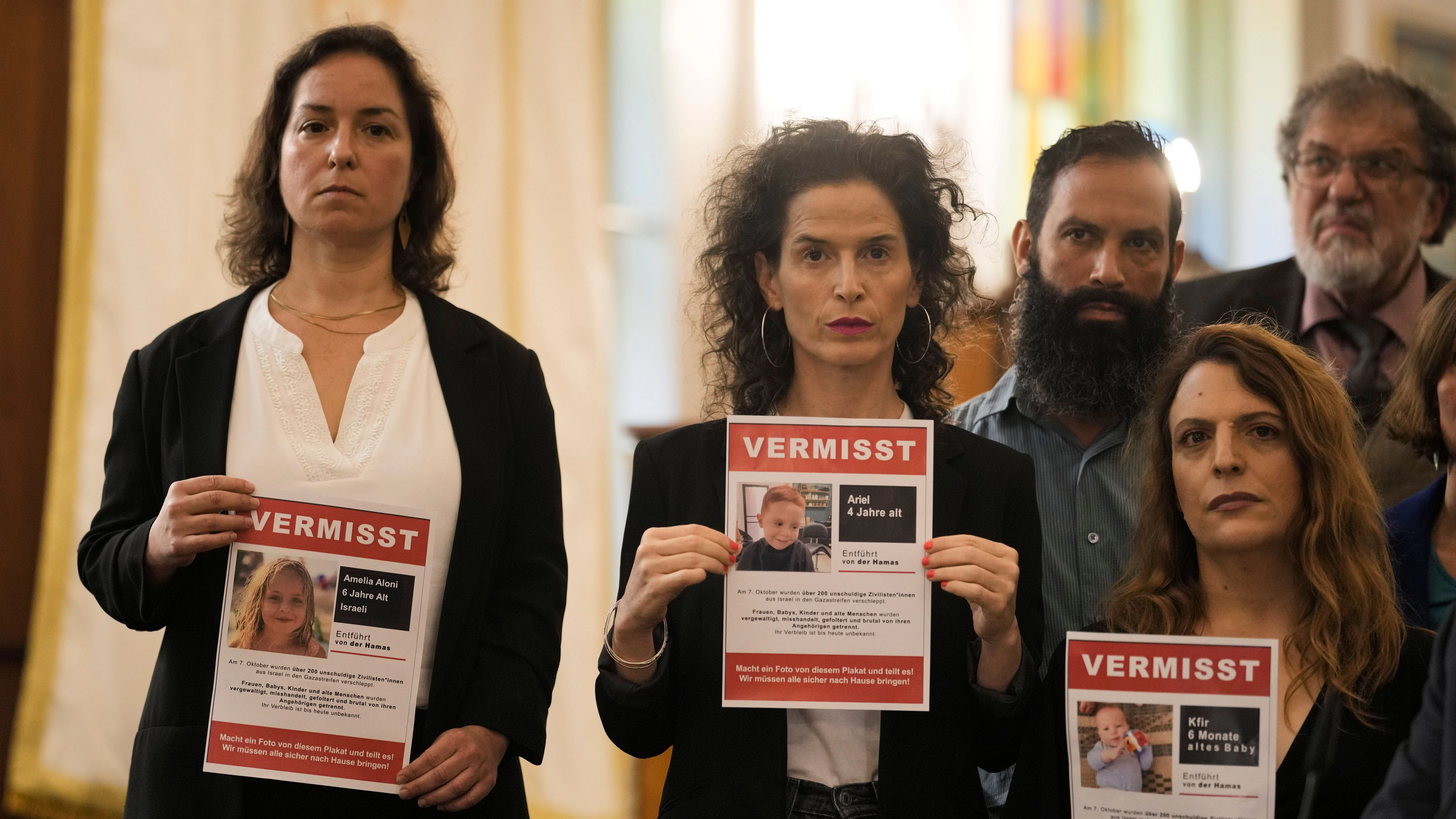 Frauen halten Plakate hoch, auf ihnen sind in Israel vermisste Kinder zu sehen.&nbsp;