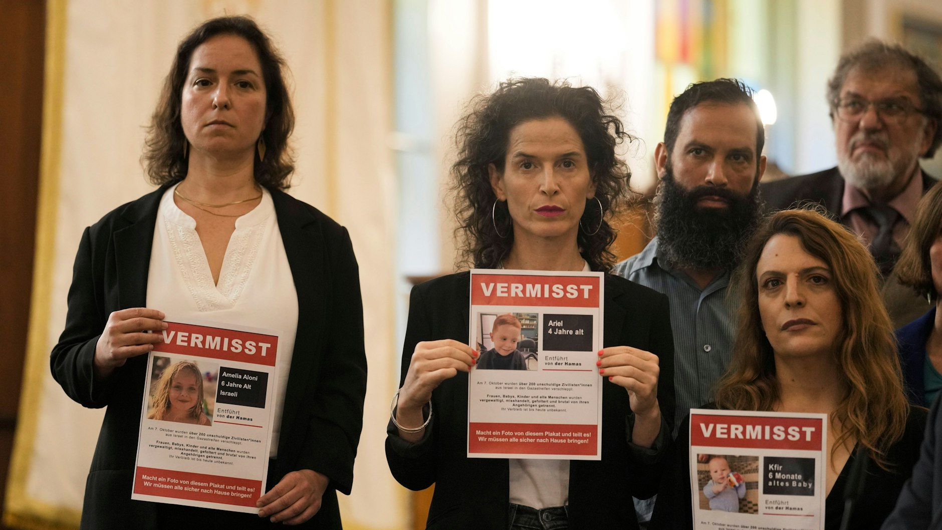 Frauen halten Plakate hoch, auf ihnen sind in Israel vermisste Kinder zu sehen.&nbsp;