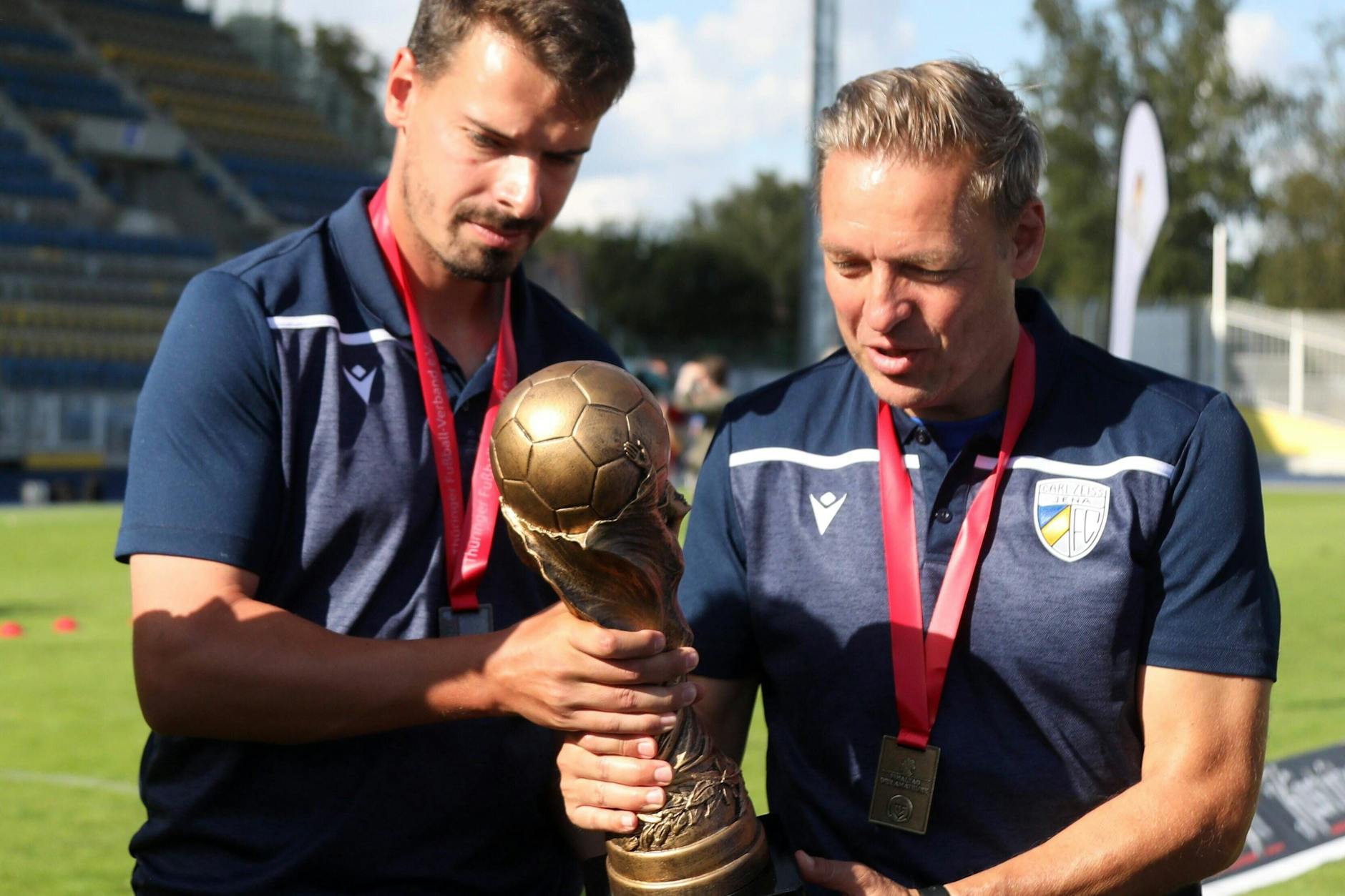 Hat was von WM-Pokal, ist aber die Trophäe für den Pokalsieger in Thüringen: BFC-Trainer Dirk Kunert (r.) bestaunt das Ding als Jena-Coach im Jahr 2020 zusammen mit seinem damaligen Co-Trainer Mounier Raychouni.