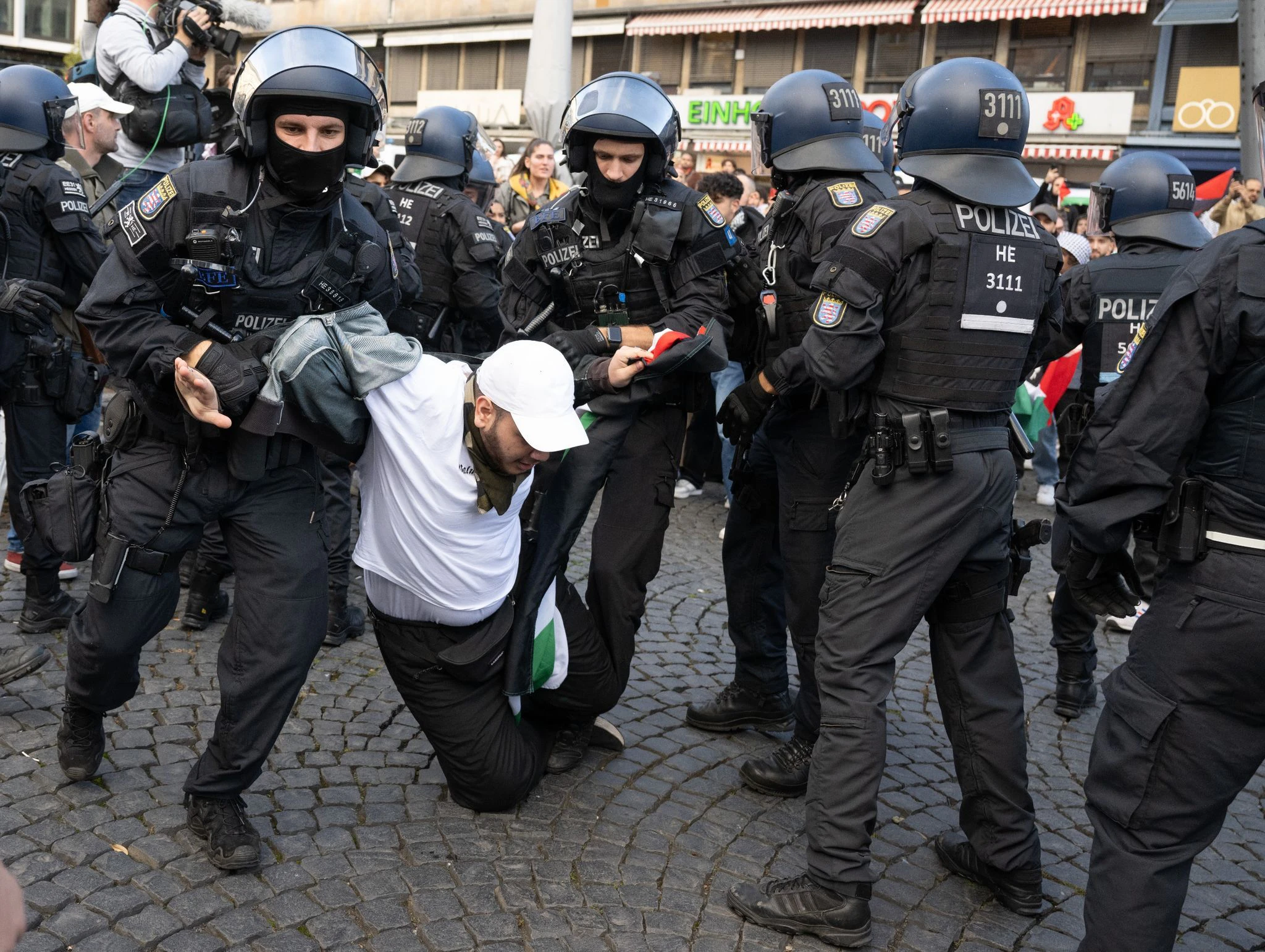 Polizisten halten am Rande der Pro-Palästina-Demo in Frankfurt am Main einen Teilnehmer fest.  
