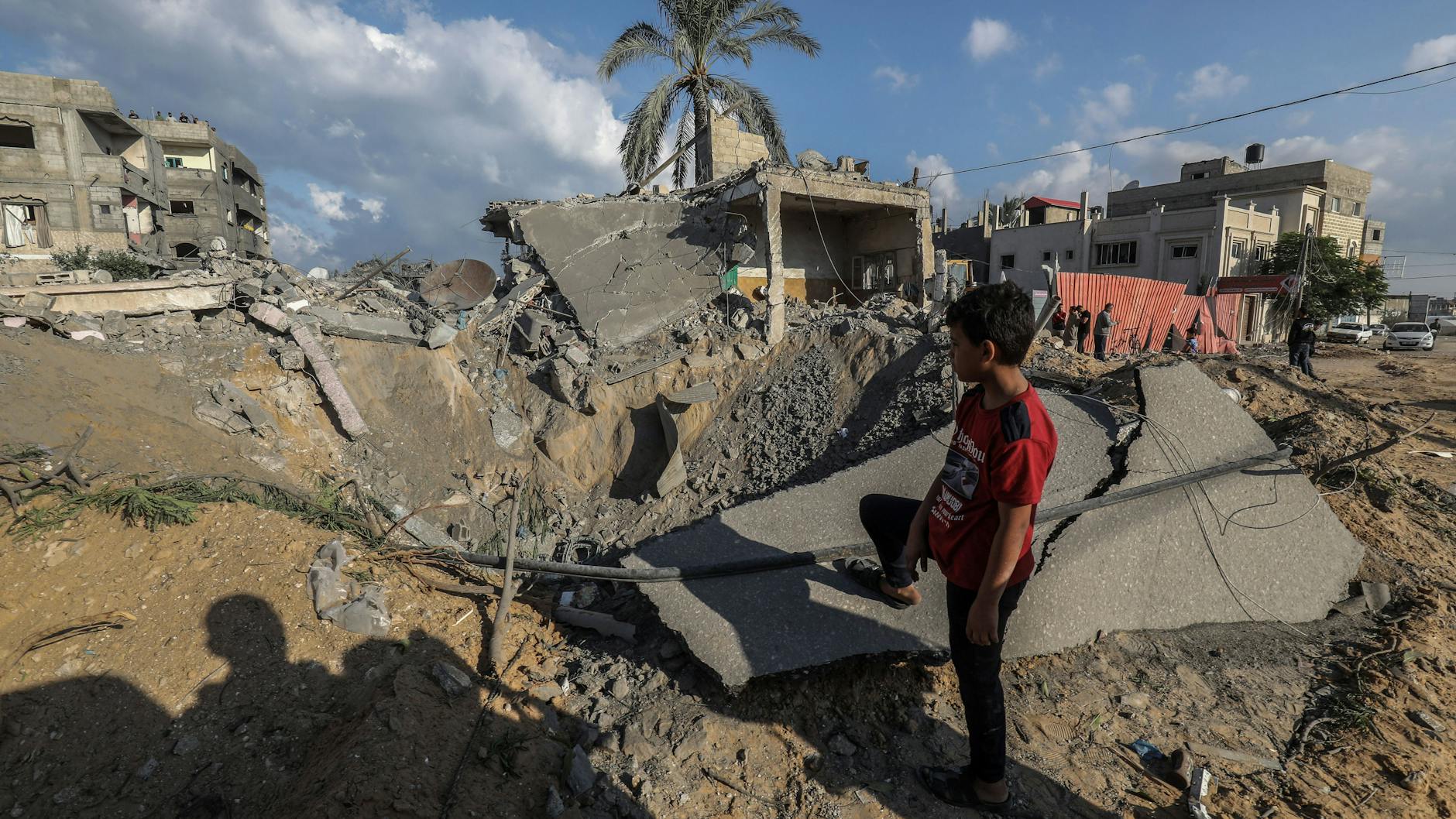 Ein palästinensischer Junge steht vor einem durch einen israelischen Luftangriff zerstörten Haus.