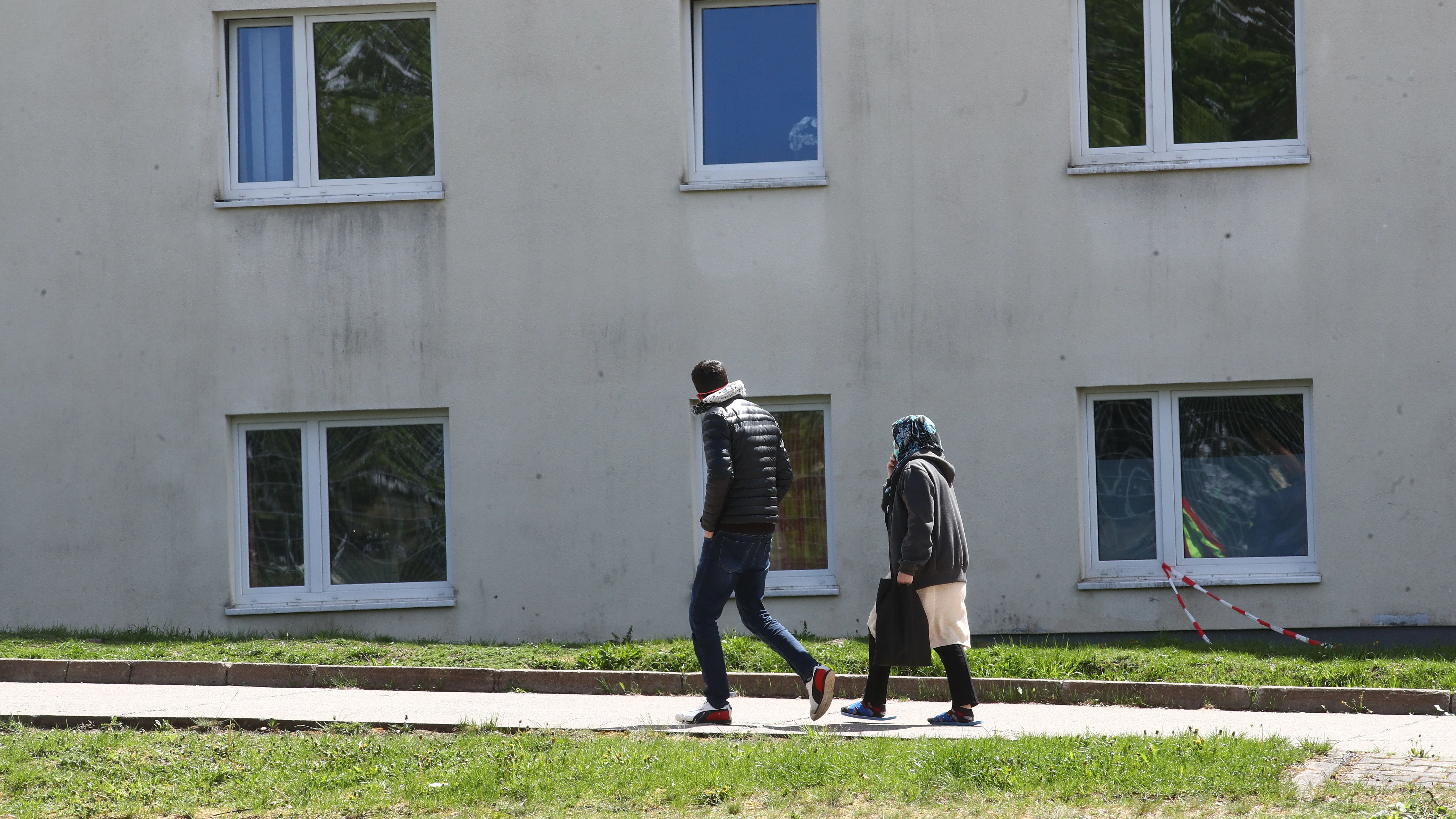 Asylbewerber gehen auf dem Gelände der Erstaufnahmeeinrichtung des Landes Thüringen spazieren. 