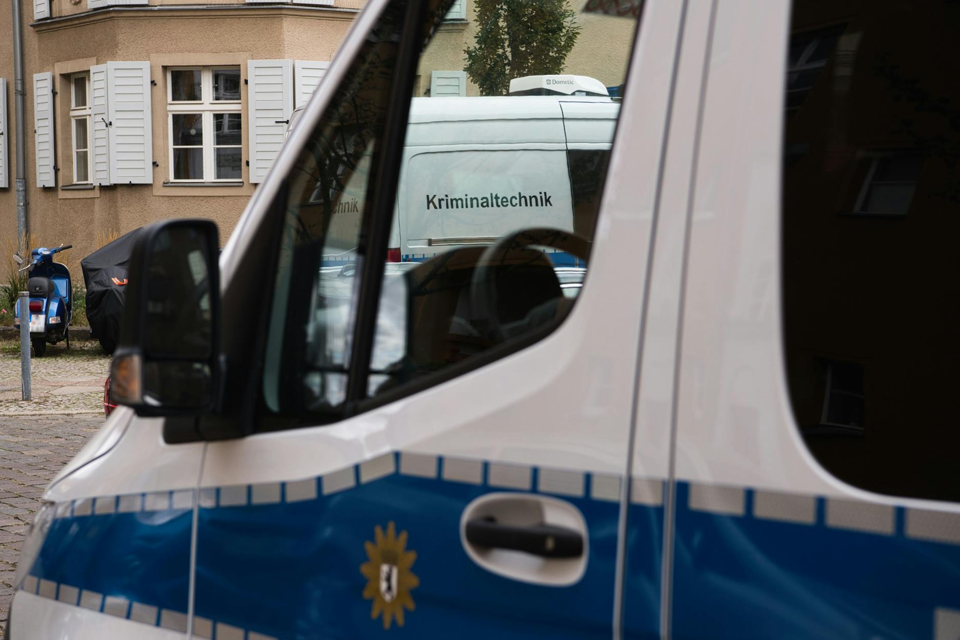 Der Wagen der Kriminaltechnik der Polizei steht vor einer Häuserzeile an der Kinzerallee im Berliner Stadtteil Köpenick. Dort wurden die Leichen einer Frau und eines Kindes in einer Wohnung gefunden.