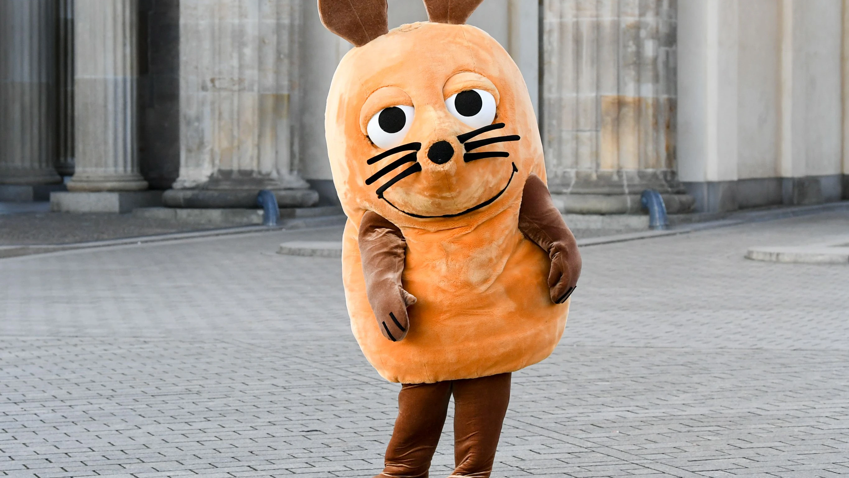 Die orange Maus aus der „Die Sendung mit der Maus“ trug den Farbton schon, bevor ihn die Letzte Generation kaperte. Sie steht vor dem Brandenburger Tor, da war es noch sauber.&nbsp;