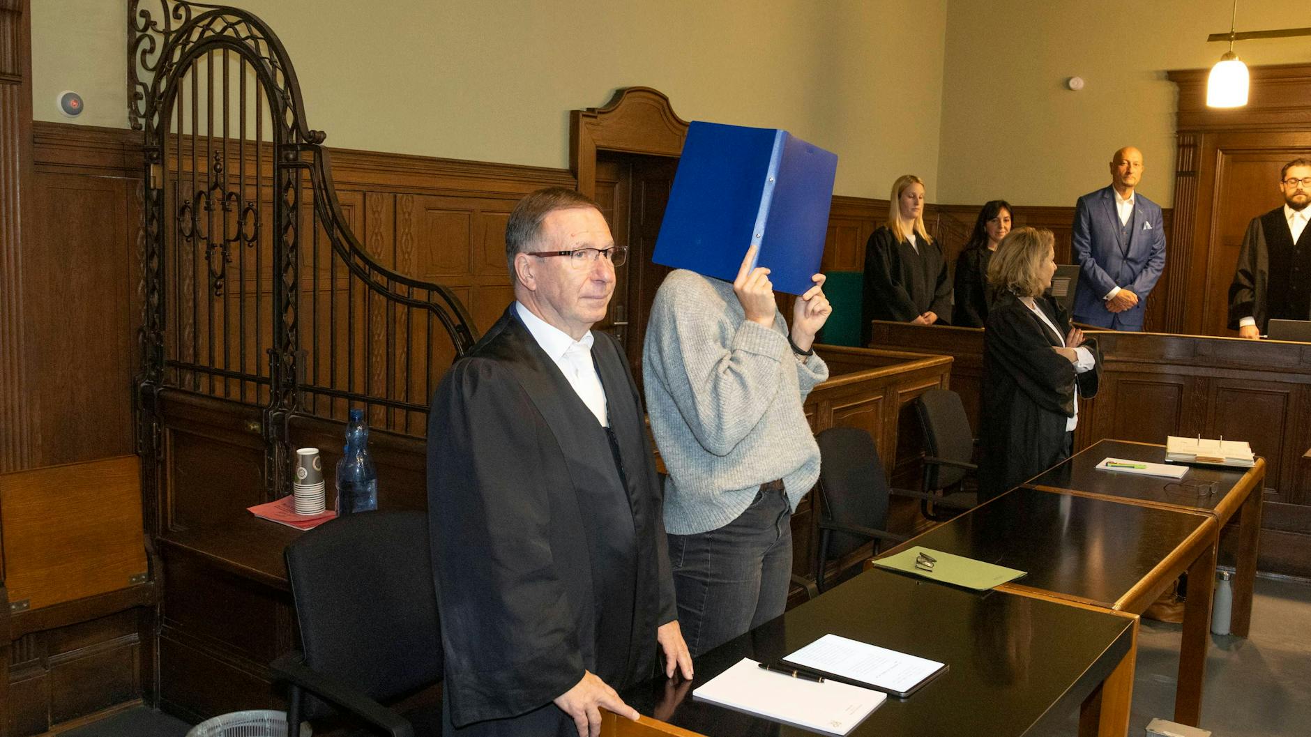 Der Platz an der Anklagebank ist noch leer. Der Arzt kam erst, als die Fotografen aus dem Gerichtssaal waren. Neben dem leeren Stuhl steht die mitangeklagte Krankenschwester.