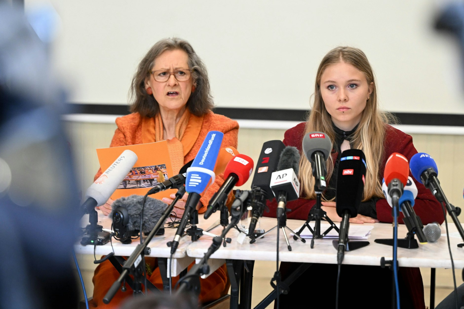 Halloween lässt grüßen: Die Klimaaktivistin Marion Fabian (links) im kürbisfarbenen Zweiteiler.&nbsp;