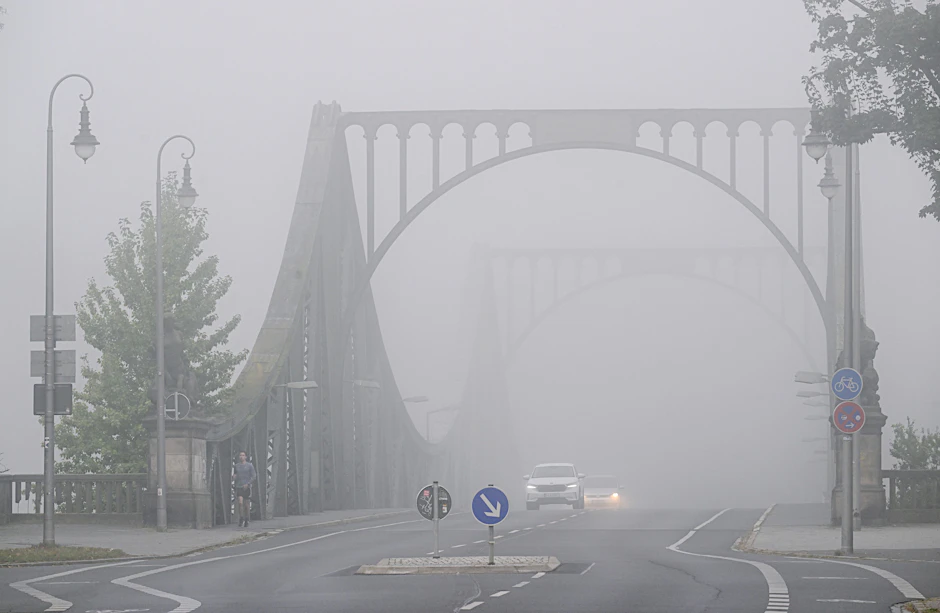 Die am Morgen über die Glienicker Brücke in Richtung Berlin fahrenden Autos haben wegen des dichten Nebels die Scheinwerfer eingeschaltet (Symbolbild).