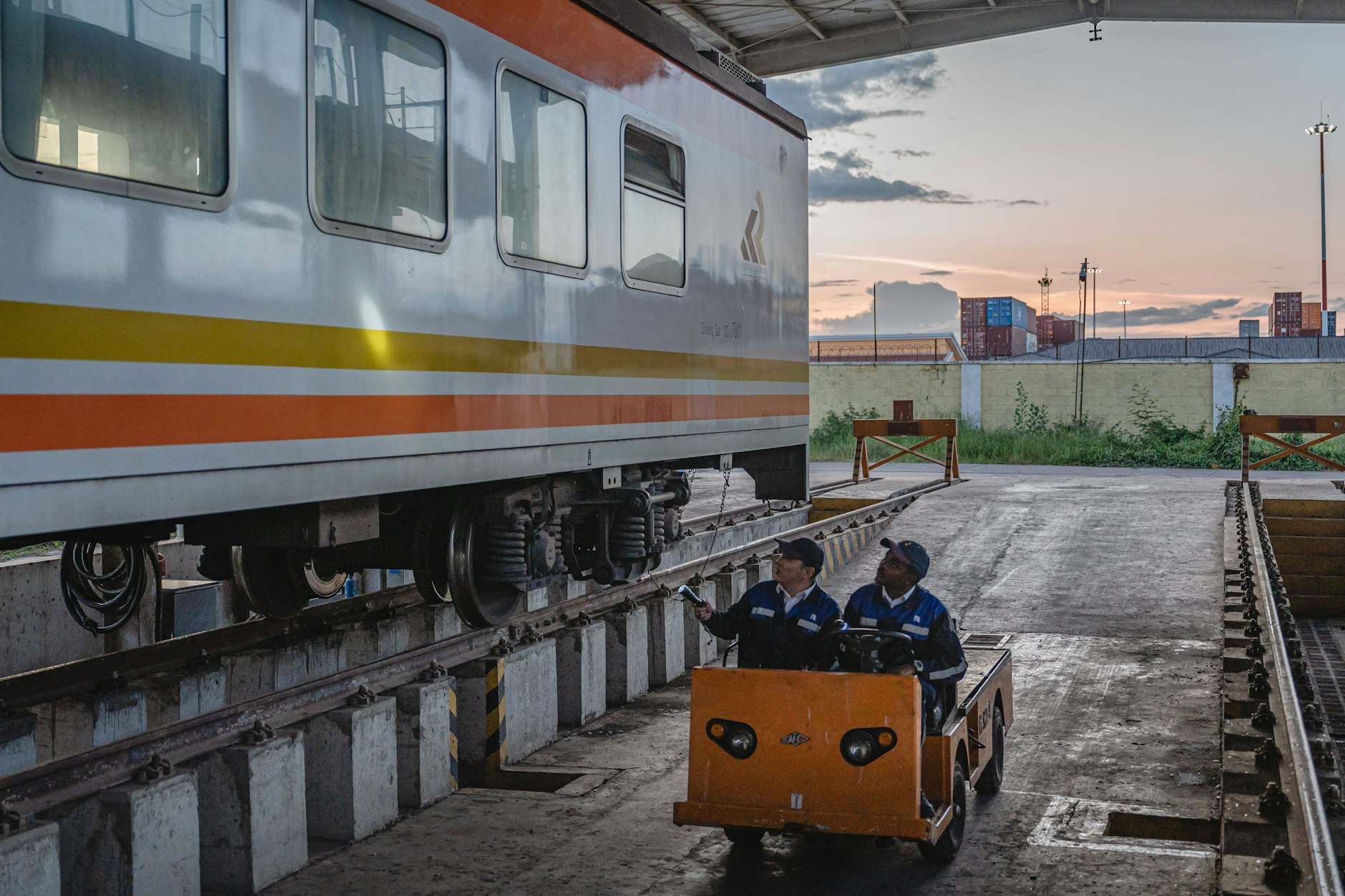 Ein chinesischer Ausbilder und ein einheimischer Auszubildender inspizieren einen Zug der Mombasa-Nairobi Railway in Nairobi, Kenia.