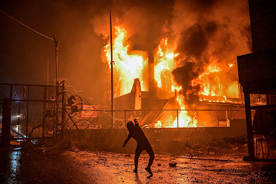 Ein Demonstrant wirft nach dem Angriff auf das Krankenhaus im Gazastreifen Steine auf ein brennendes Gebäude in der Nähe der US-Botschaft in Beirut.&nbsp;