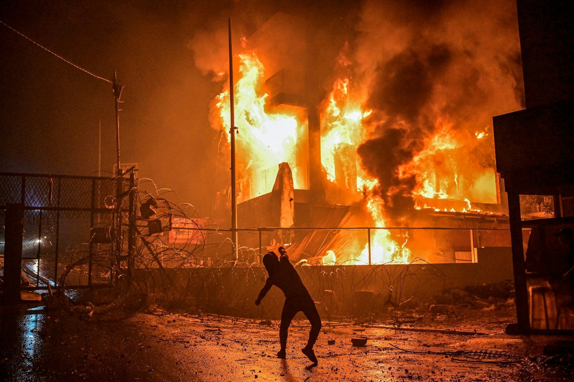 Ein Demonstrant wirft nach dem Angriff auf das Krankenhaus im Gazastreifen Steine auf ein brennendes Gebäude in der Nähe der US-Botschaft in Beirut.&nbsp;