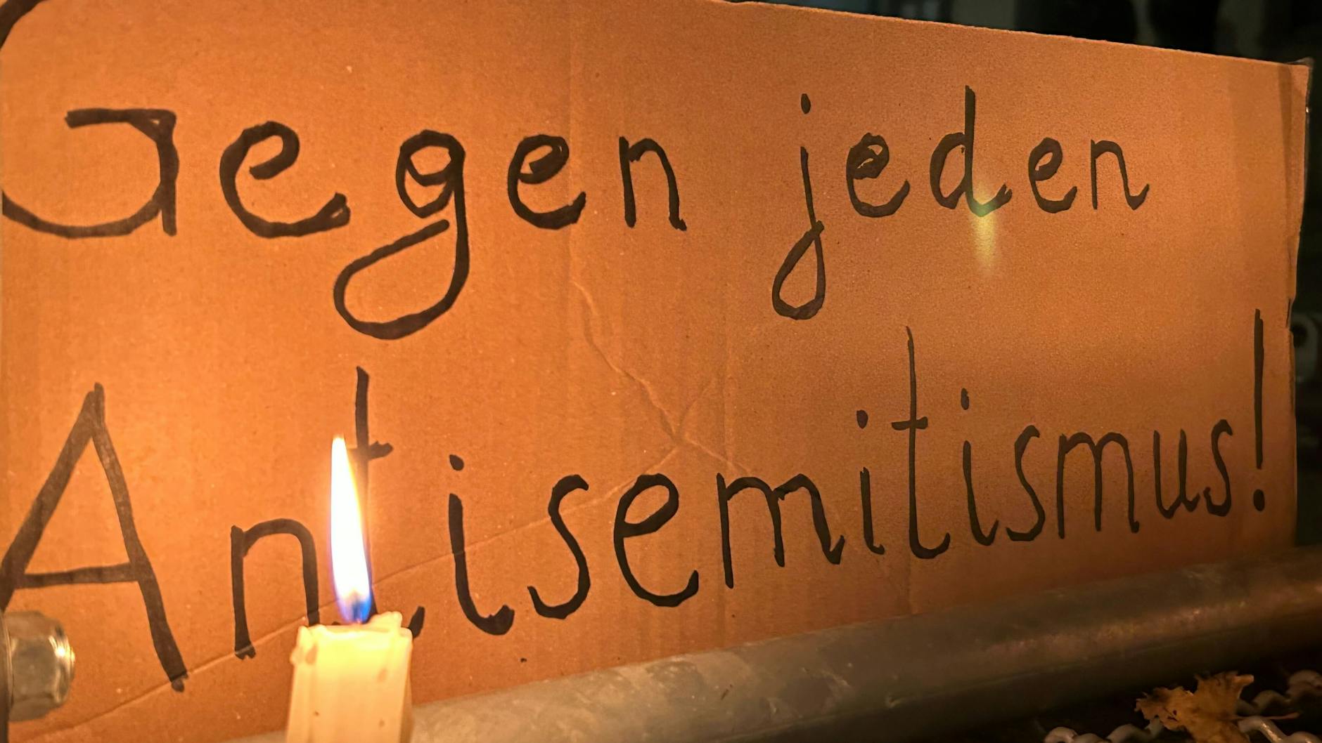 Eine brennende Kerze steht vor einem Schild mit der Aufschrift „Gegen jeden Antisemitismus“ bei einer Mahnwache gegen Antisemitismus nach dem versuchten Brandanschlag auf die Synagoge in der Berliner Brunnenstraße. 
