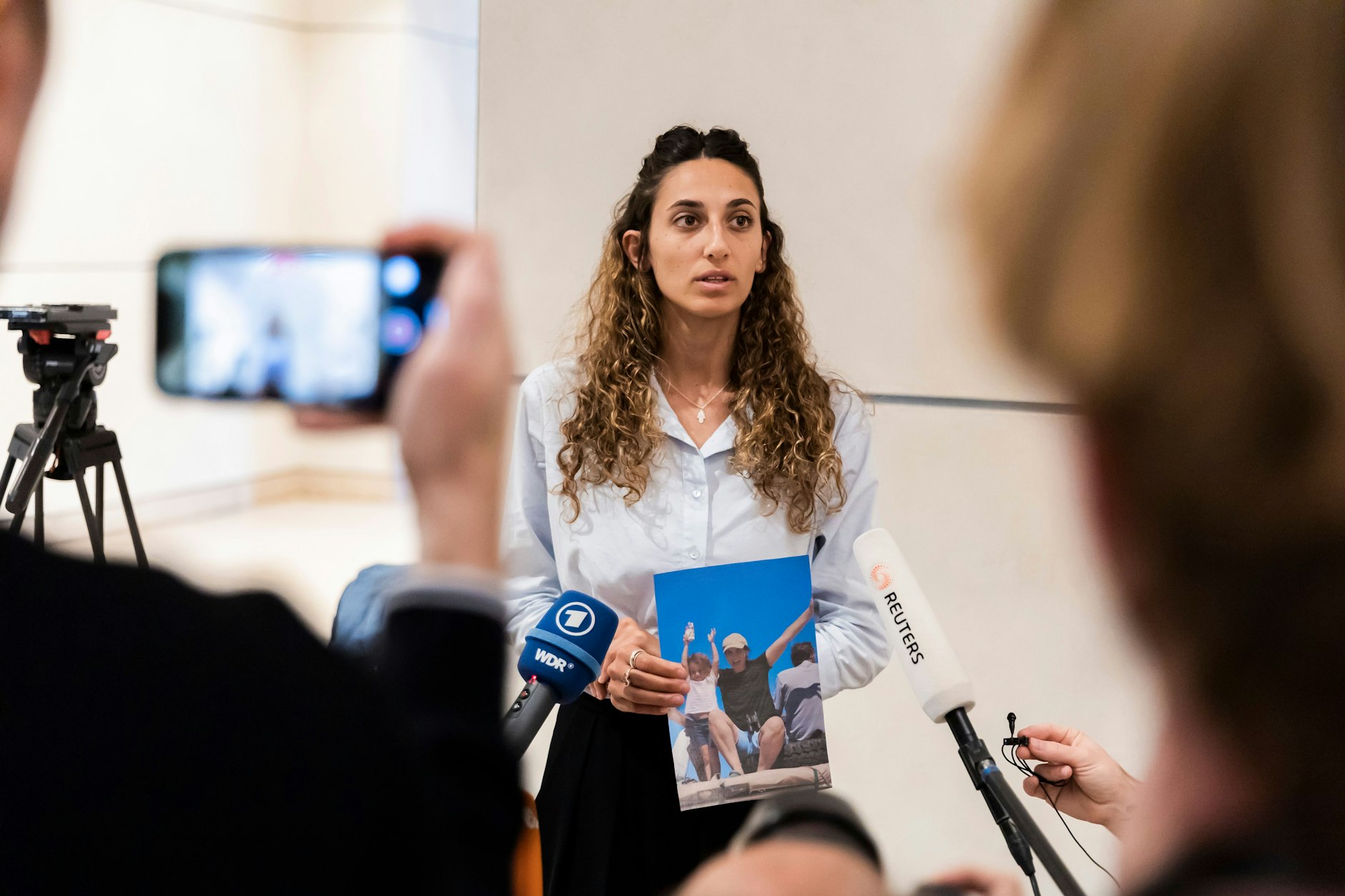 Roni Roman ist die Schwester der von der Hamas entführten Yarden und deren Tochter Geffen. Sie hält ihr Bild in den Händen.