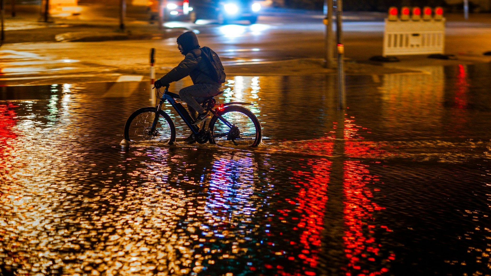 Ein Radfahrer fährt durch das Hochwasser am Stadthafen von Wismar.&nbsp;