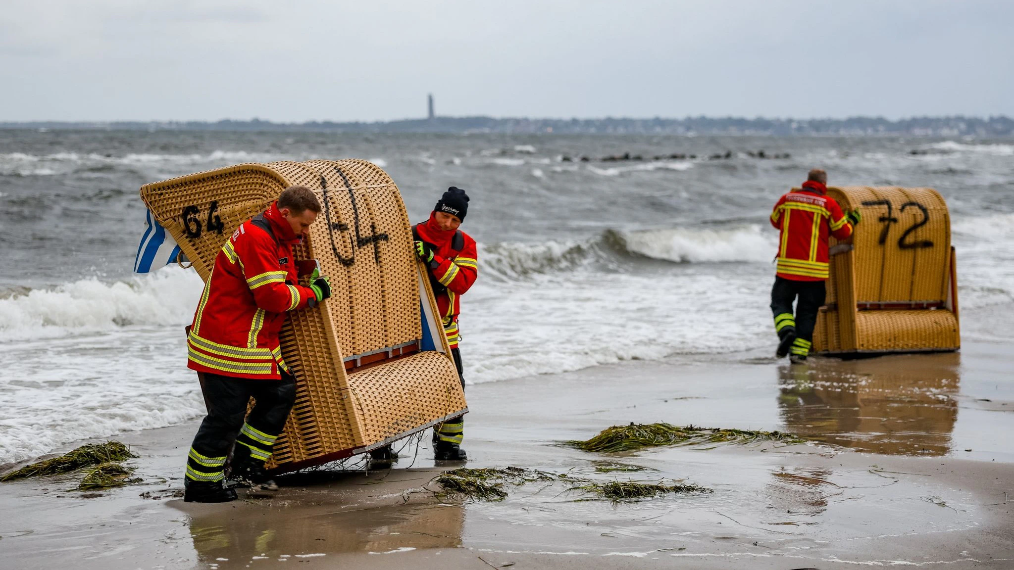 Einsatzkräfte der Feuerwehr sichern in  in Kiel-Schiksee Strandkörbe vor den Flutwellen der Ostsee.&nbsp;