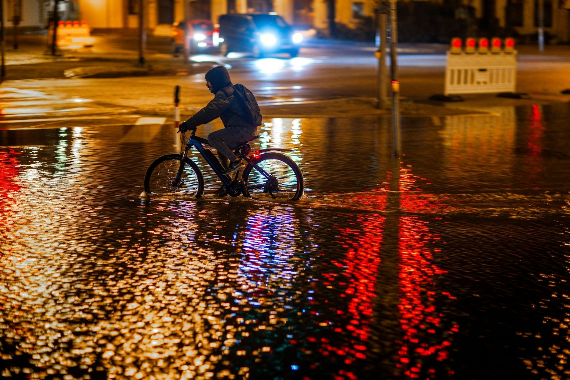 Ein Radfahrer fährt durch das Hochwasser am Stadthafen von Wismar.&nbsp;