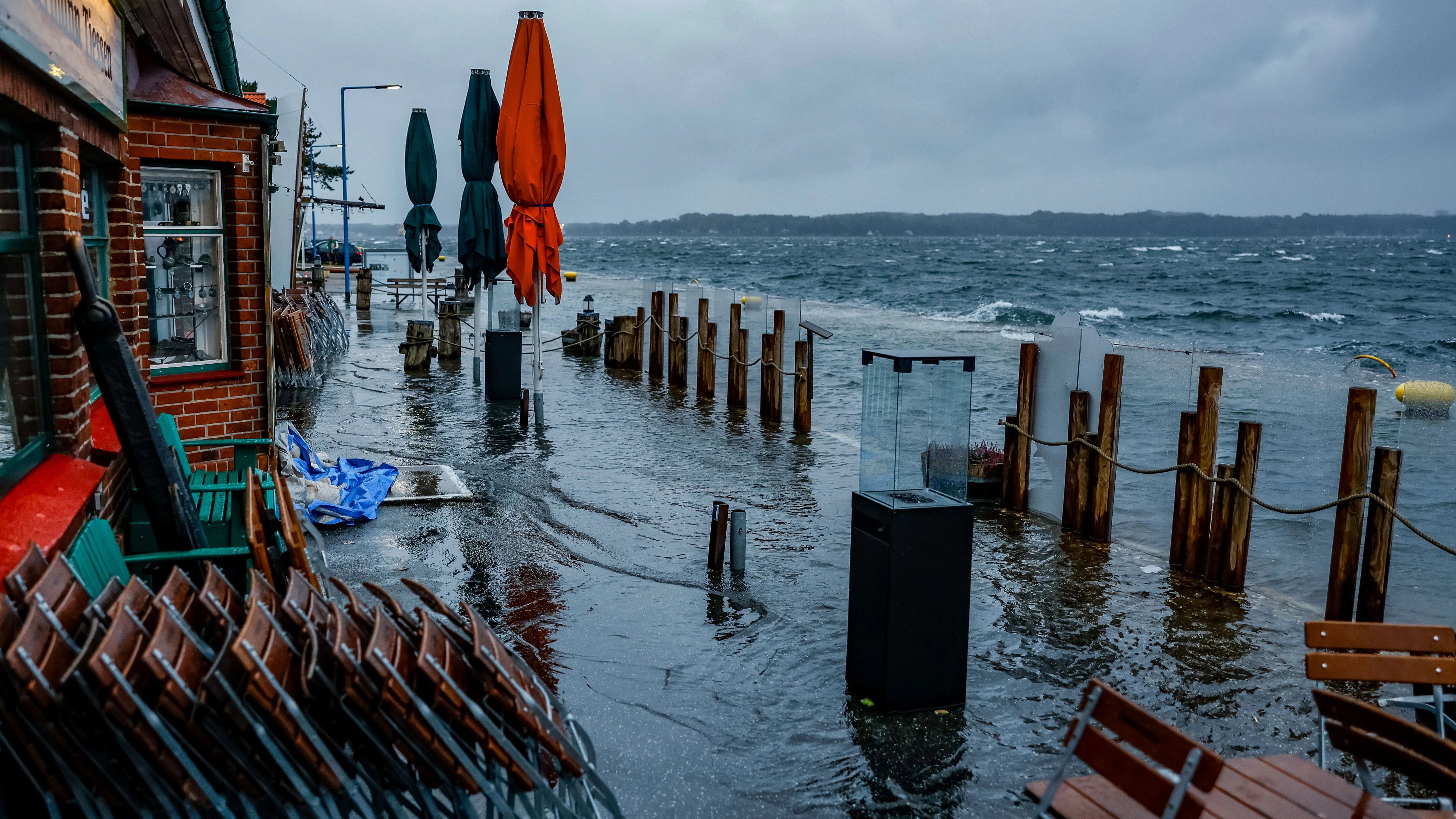 Die Straße vor den Cafés und Geschäften am Tiessenkai im Kieler Stadteil Holtenau ist vollständig von der Ostsee überflutet.