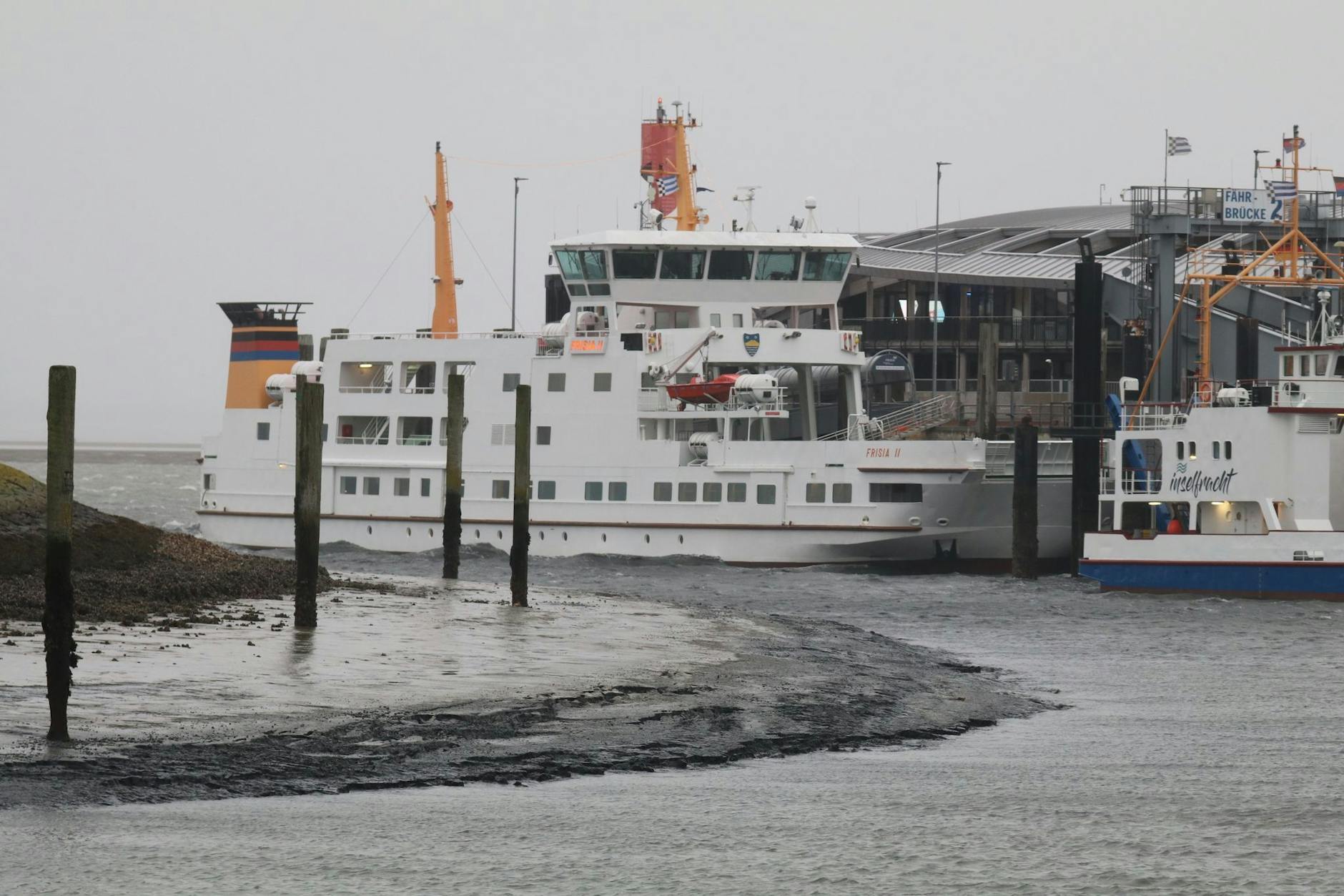 Eine Fähre liegt bei Niedrigwasser im Hafenbecken der Insel Norderney.