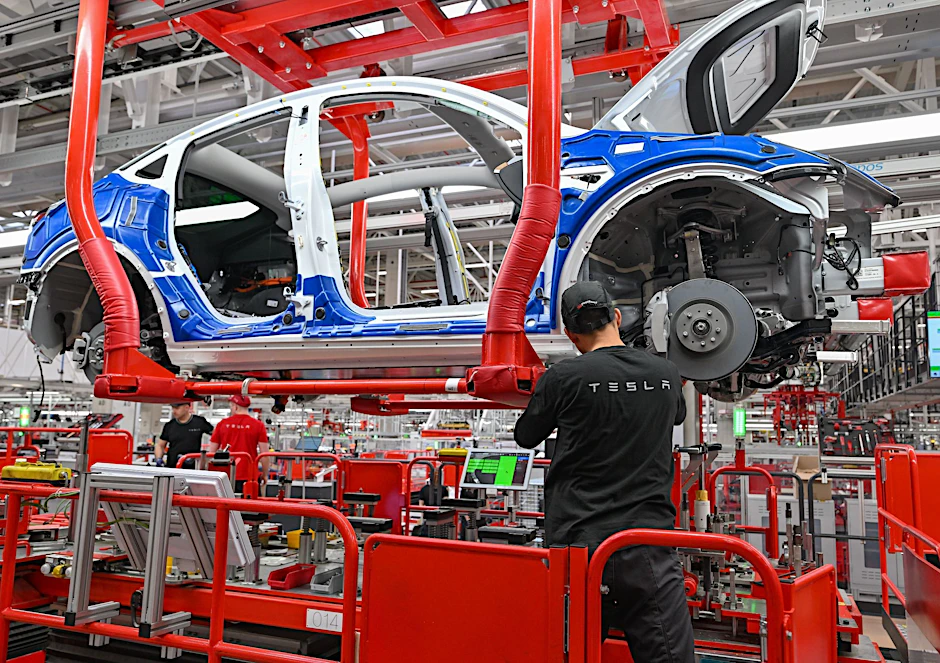 ARCHIV - Ein Mitarbeiter im Tesla-Werk in Grünheide an einer Fertigungslinie für Elektrofahrzeuge vom Typ Model Y.  