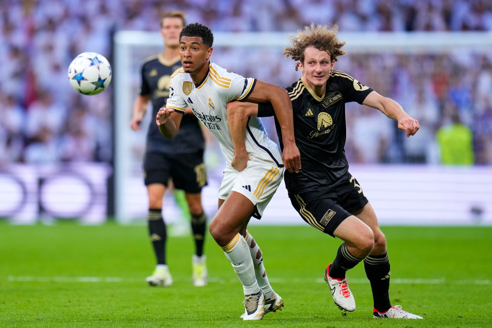 Real Madrids Jude Bellingham (l) und Unions Alex Kral im Zweikampf.  