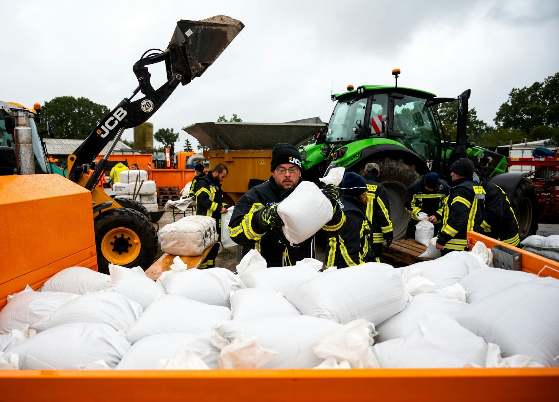Feuerwehrleute füllen in Grömitz in Ostholstein Sandsäcke.  