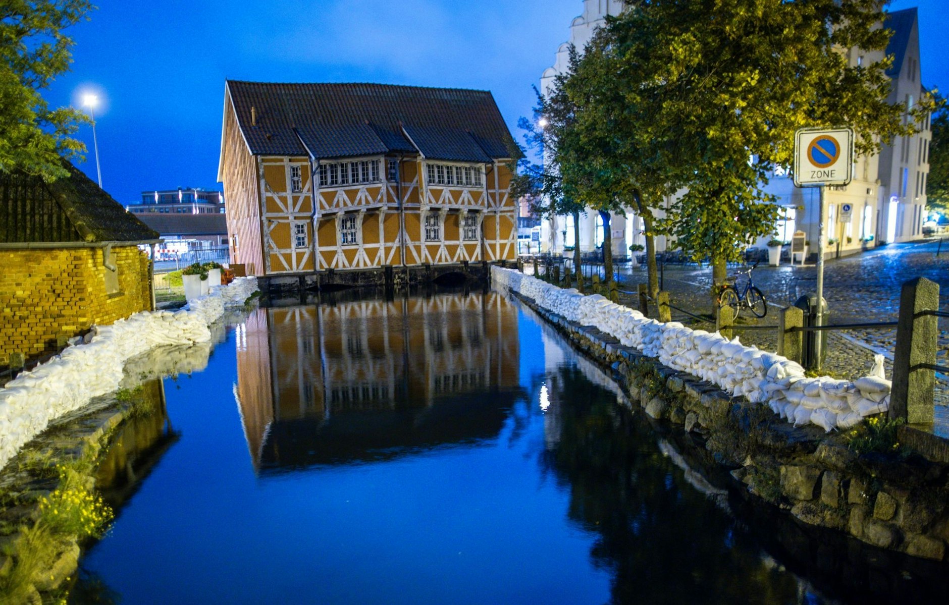 Sandsackmauern sind am Stadthafen von Wismar zum Schutz vor Hochwasser aufgestapelt. Wegen einer erwarteten Sturmflut an der Ostseeküste sind Uferbereiche in der Nähe des Hafens bereits teilweise überflutet.  