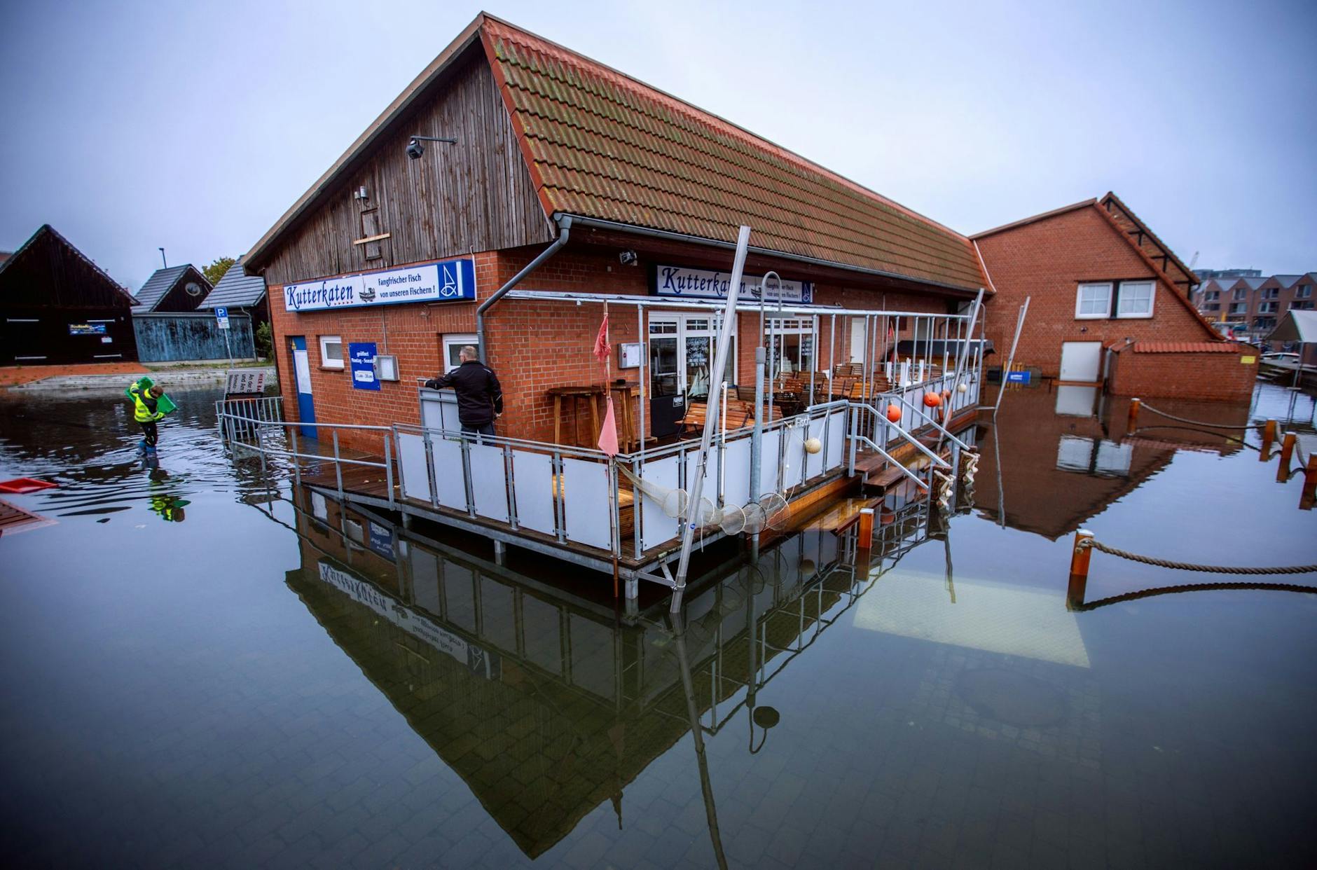 Gebäude im Fischereihafen in Wismar stehen nach der Sturmflut an der Ostseeküste im Wasser.
