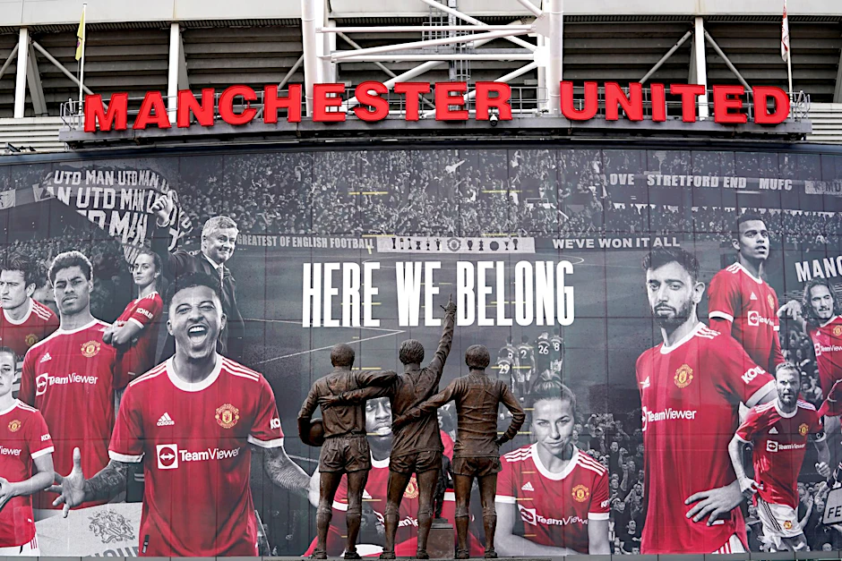 ARCHIV - Vor dem Stadion Old Trafford stehen Statuen der ehemaligen Manchester-United-Spieler George Best, Denis Law und Sir Bobby Charlton.  