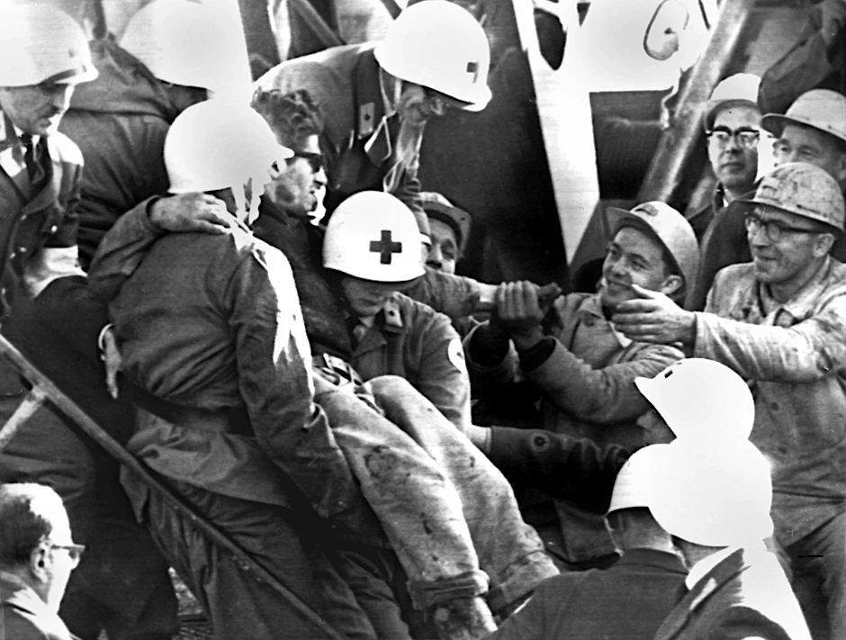 ARCHIV - Helfer tragen einen der befreiten Bergleute ins Freie.  