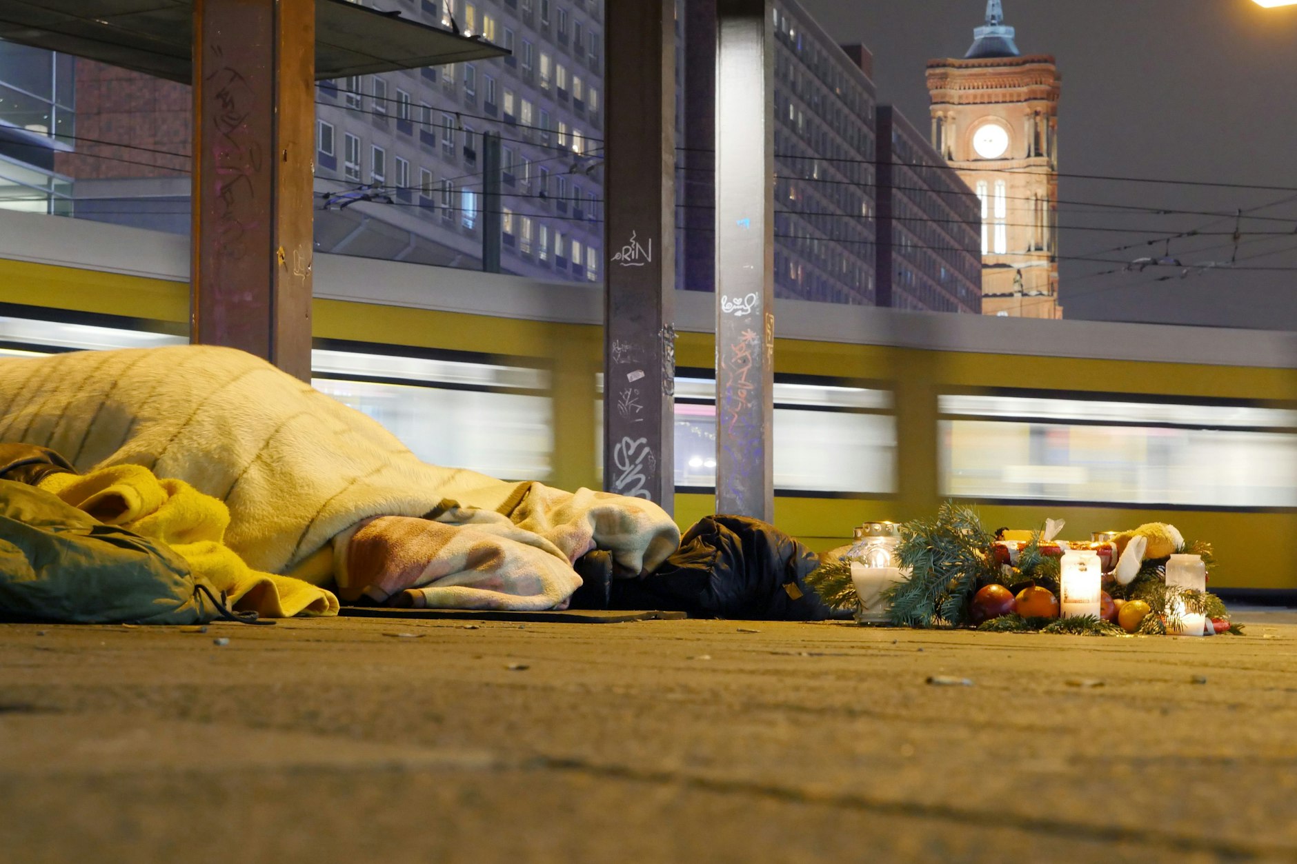 Ein Obdachloser übernachtet an einer Bushaltestelle am Roten Rathaus in Mitte.