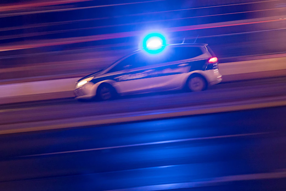 Ein Streifenwagen der Berliner Polizei fährt mit Blaulicht über die BAB 100.