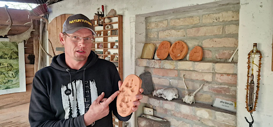 PRODUKTION - Wildnispädagoge Paul Wernicke zeigt in seiner Wildnisschule in Bad Belzig den Pfotenabdruck eines Wolfes in Ton.  pa