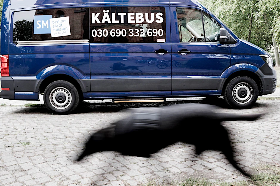 ARCHIV - Ein Hund läuft vor an einem Kältebus der Berliner Stadtmission vorbei.  