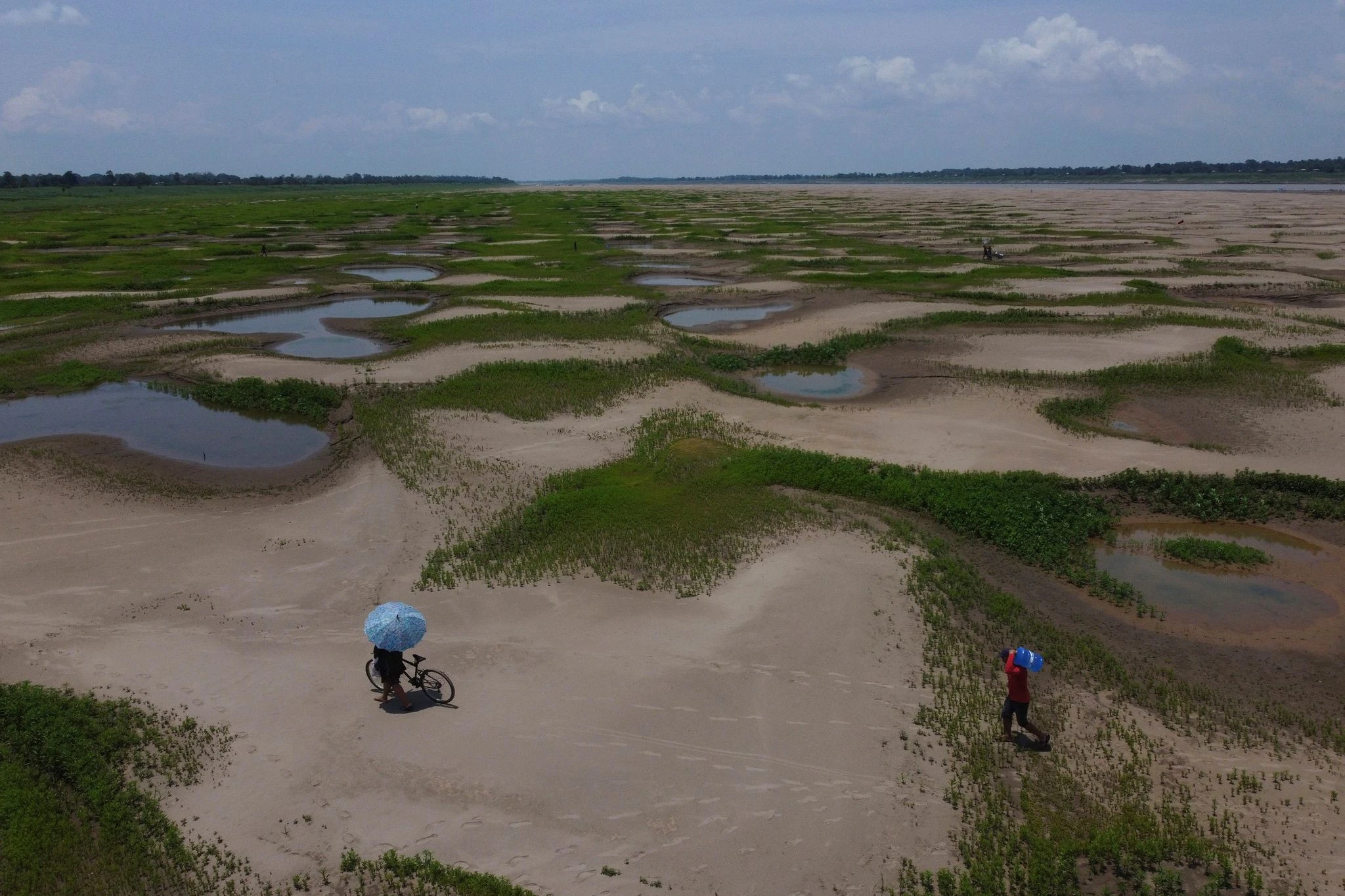 Bewohner einer Flussufergemeinde tragen Lebensmittel und Trinkwasserbehälter durch das brasilianische Amazonasgebiet Manaquiri. Aufgrund einer anhaltenden Dürre gibt es eine staatlich organisierte humanitäre Hilfsaktion.  