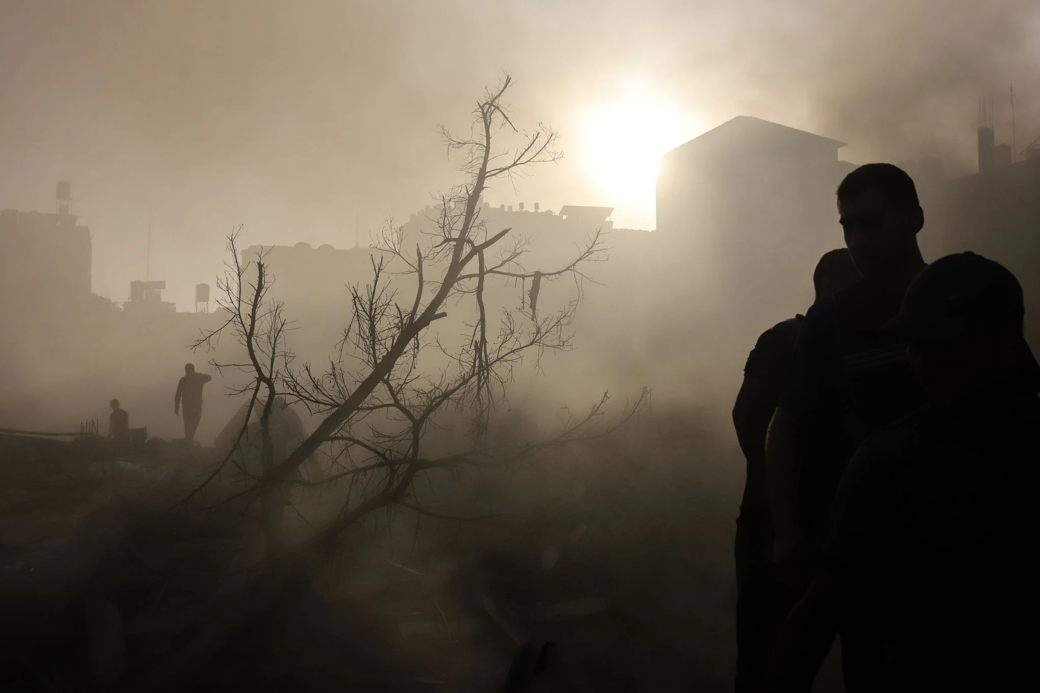 Nach einem Luftangriff auf Gaza-Stadt scheint die Sonne durch das staubige und zerstörte Gebiet.  