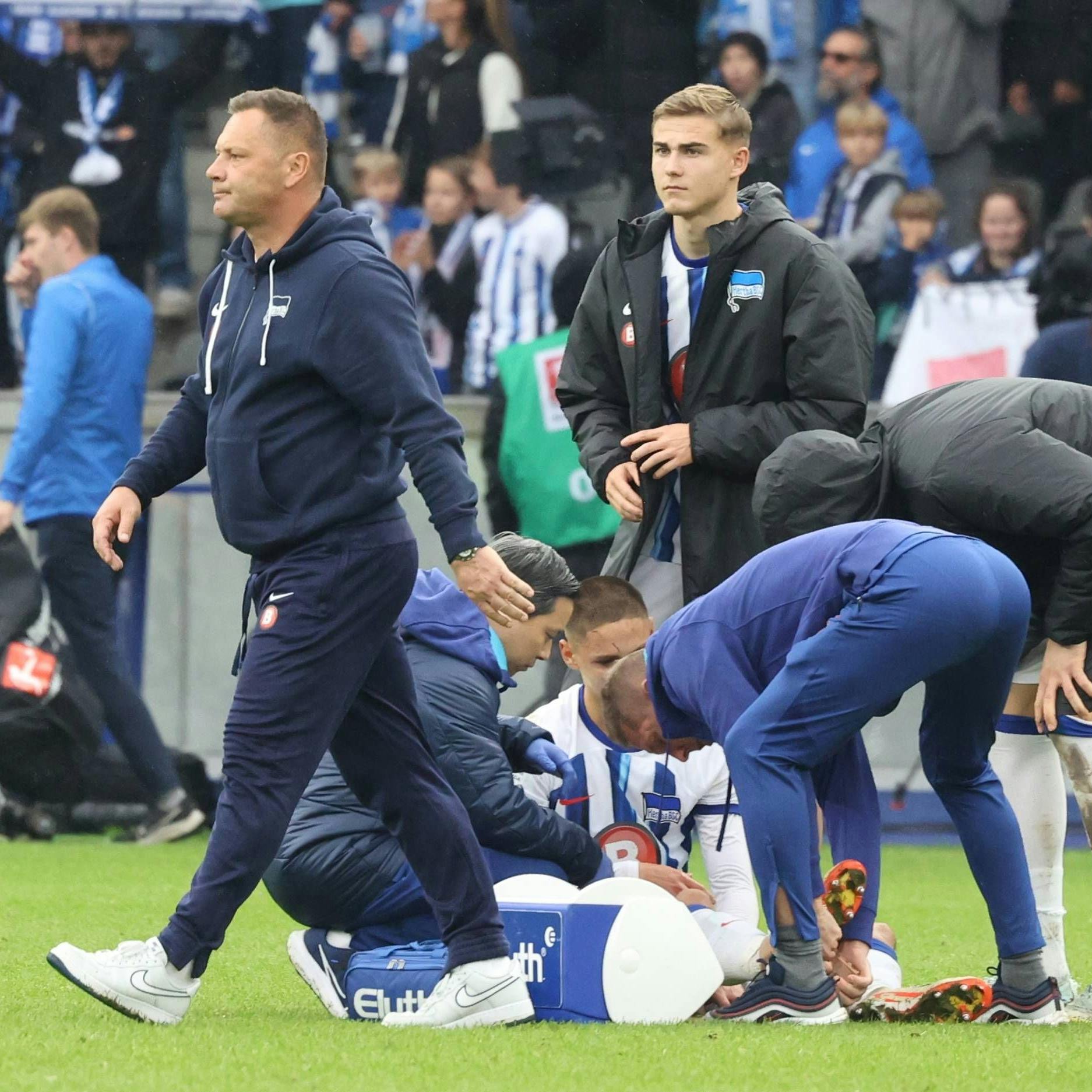 Bence Dardai wird am Knöchel behandelt und Vater Pal Dardai schaut gefrustet bis sauer.