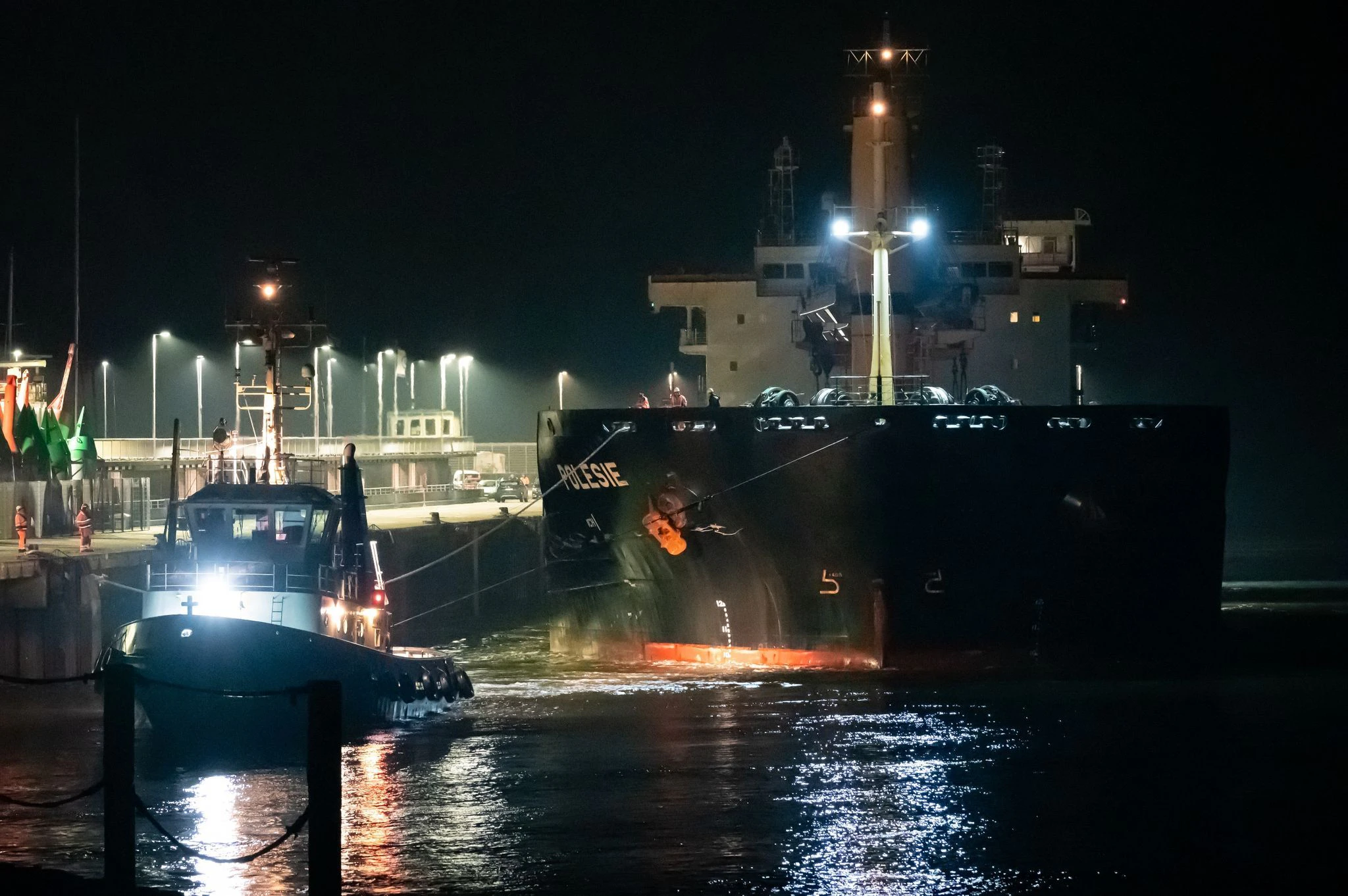dpatopbilder - Nach der Kollision mit einem anderen Frachter auf der Nordsee vor Helgoland wird das Frachtschiff «Polesie» in der Nacht von zwei Schleppern an den Kai der Seebäderbrücke in Cuxhaven gezogen.  