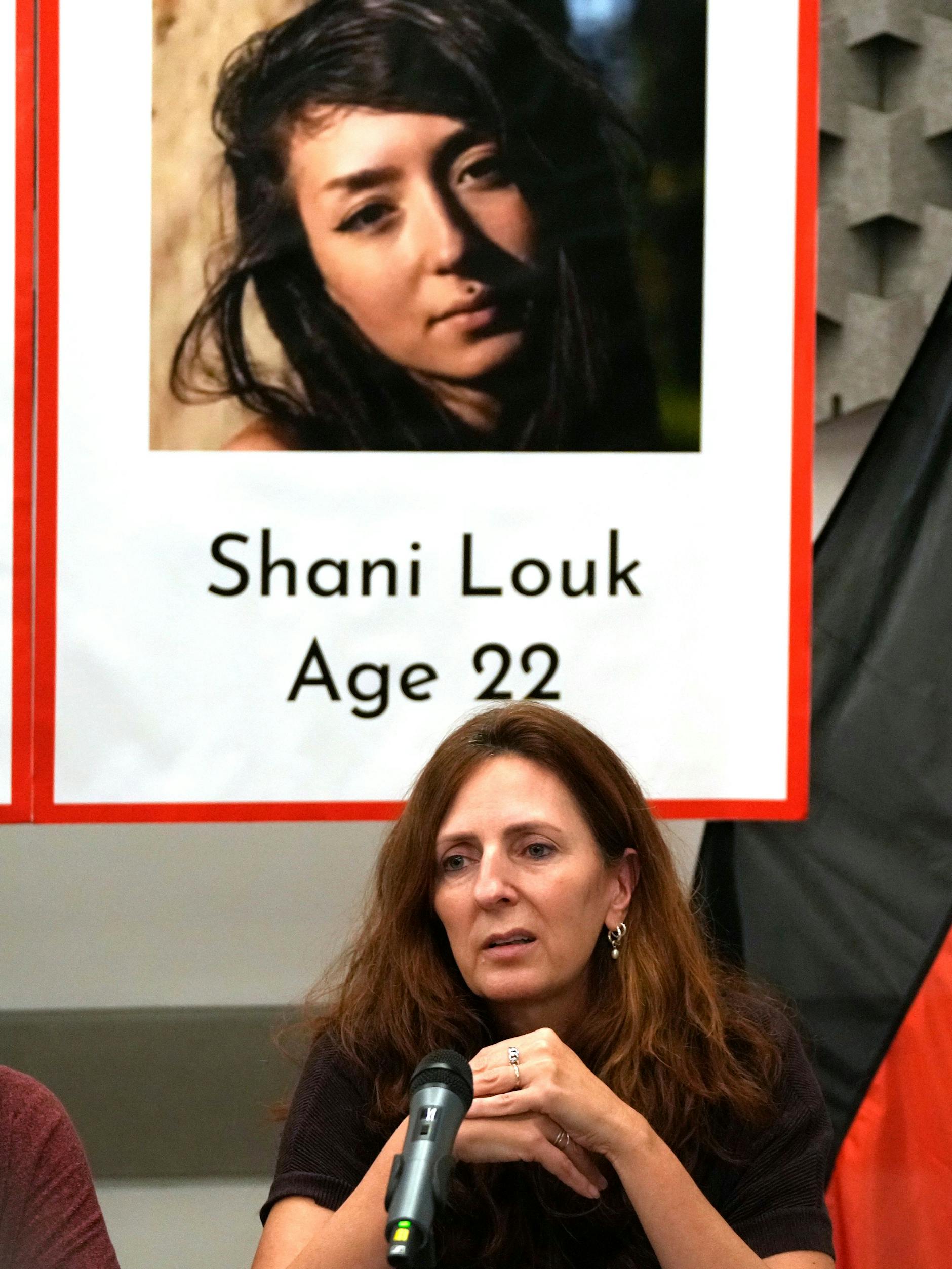 Ricarda Louk sitzt in Tel Aviv vor einem Plakat, das ihre Tochter Shani Louk zeigt. 