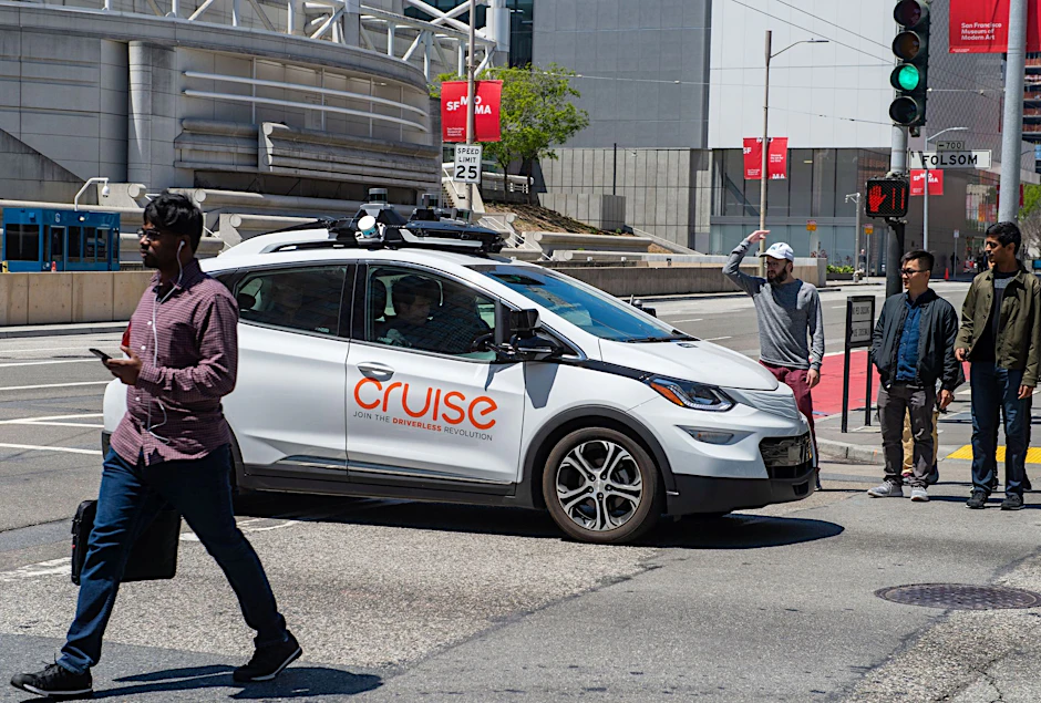 ARCHIV - Ein selbstfahrendes Auto der Roboterwagenfirma Cruise des US-Konzerns General Motors sorgt für Unmut bei Fußgängern, nachdem es auf einer Kreuzung steckenblieb und sie bei Rot verlässt.  