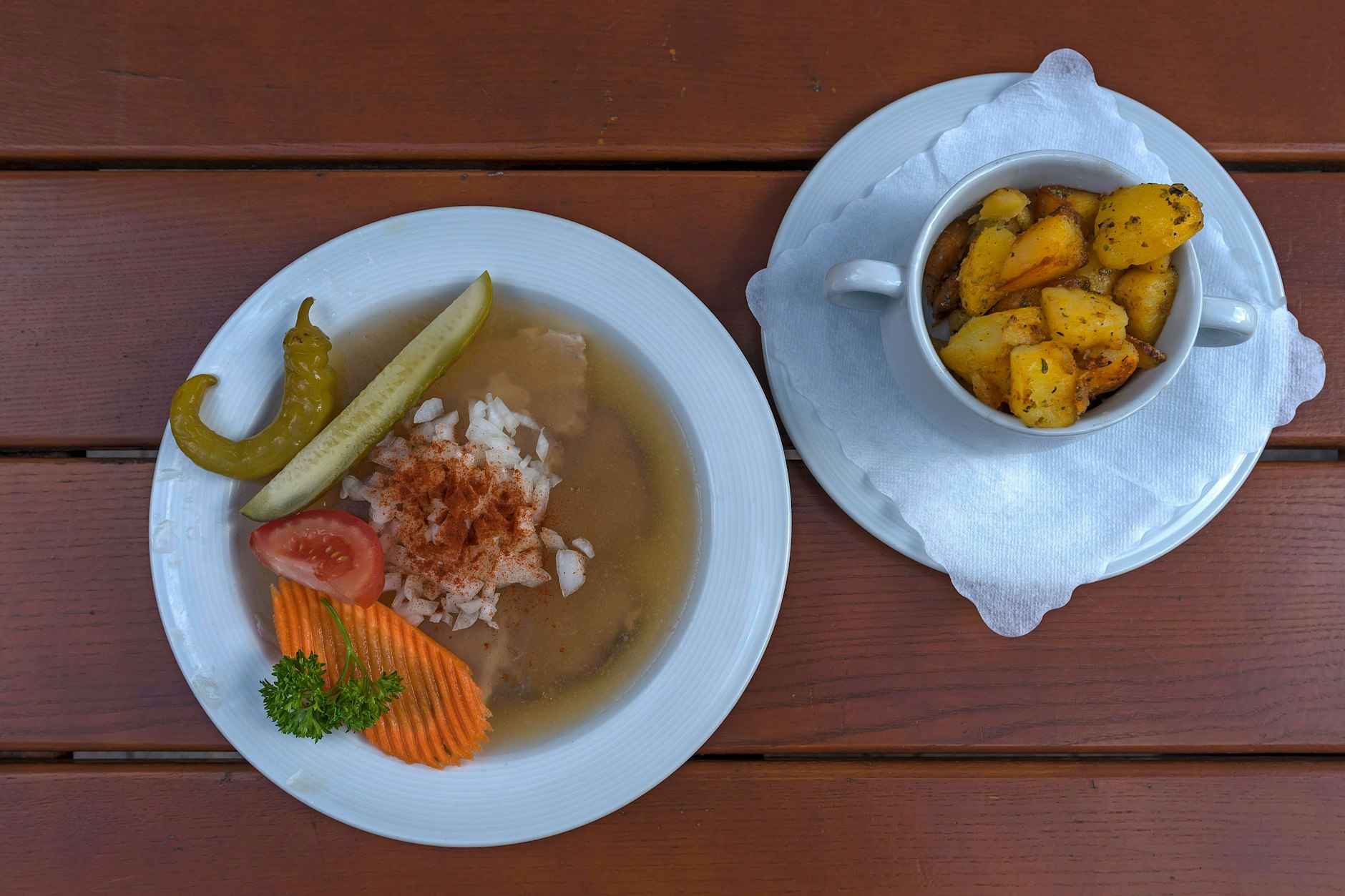 Sülzkotelett serviert auf einem weißen Teller, garniert mit frischen Kräutern.