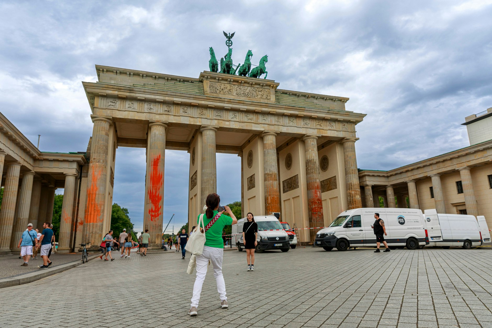 Touristen machen Fotos vom geschändeten Brandenburger Tor in Berlin.